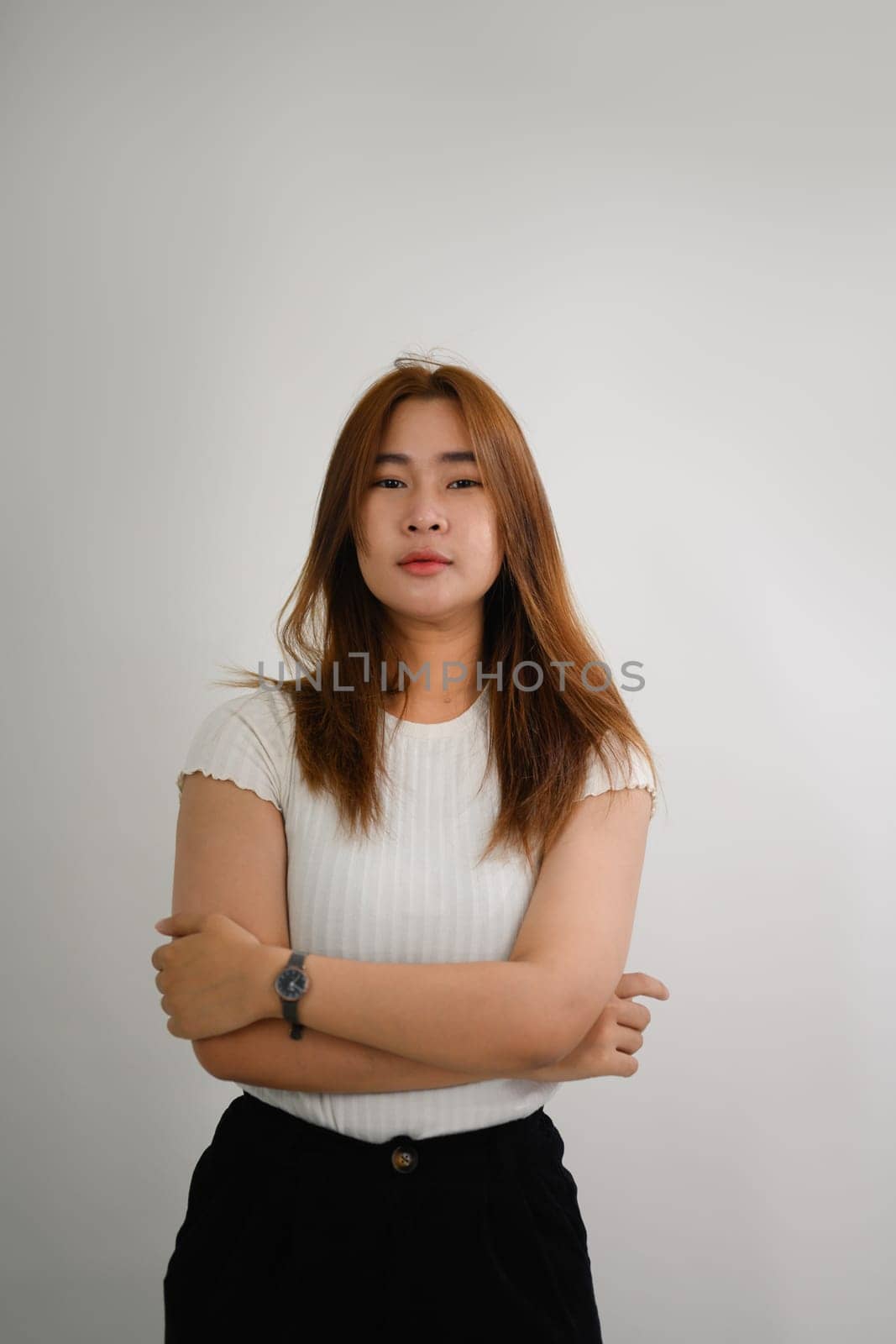 Portrait of pretty young Asian woman posing against white background.