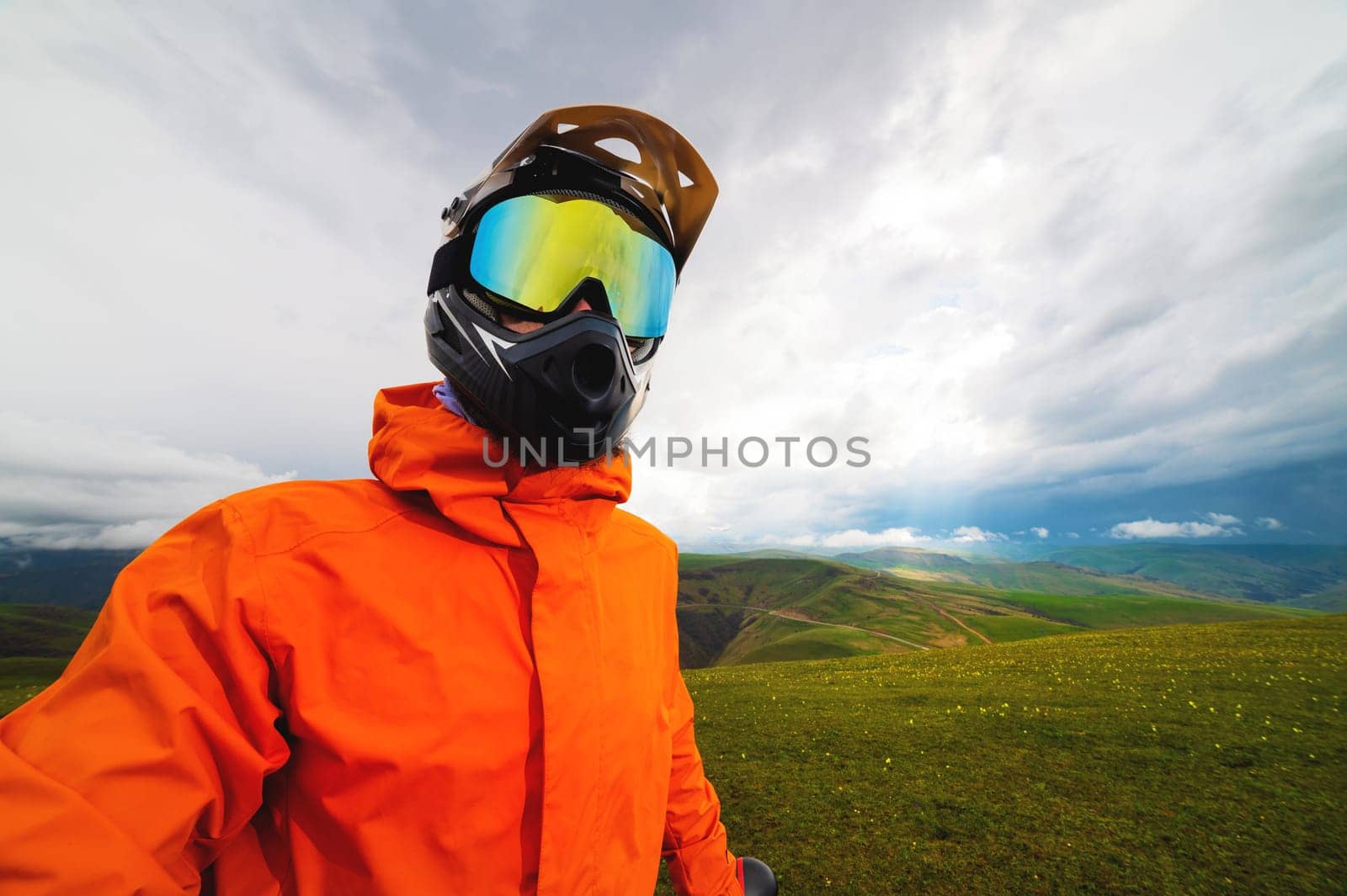 Portrait of a racer in full protection of a full face mask on a bicycle or motorcycle in the summer mountains. The concept of attracting youth to outdoor sports by yanik88