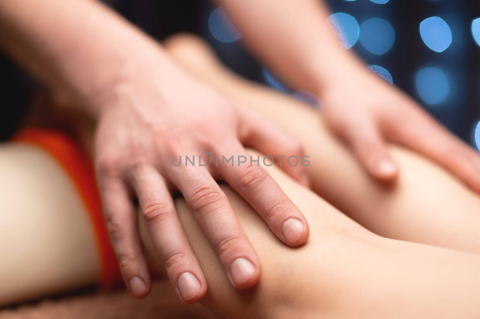 Massage stroking the ankle muscles in a professional office in a shallow depth of field