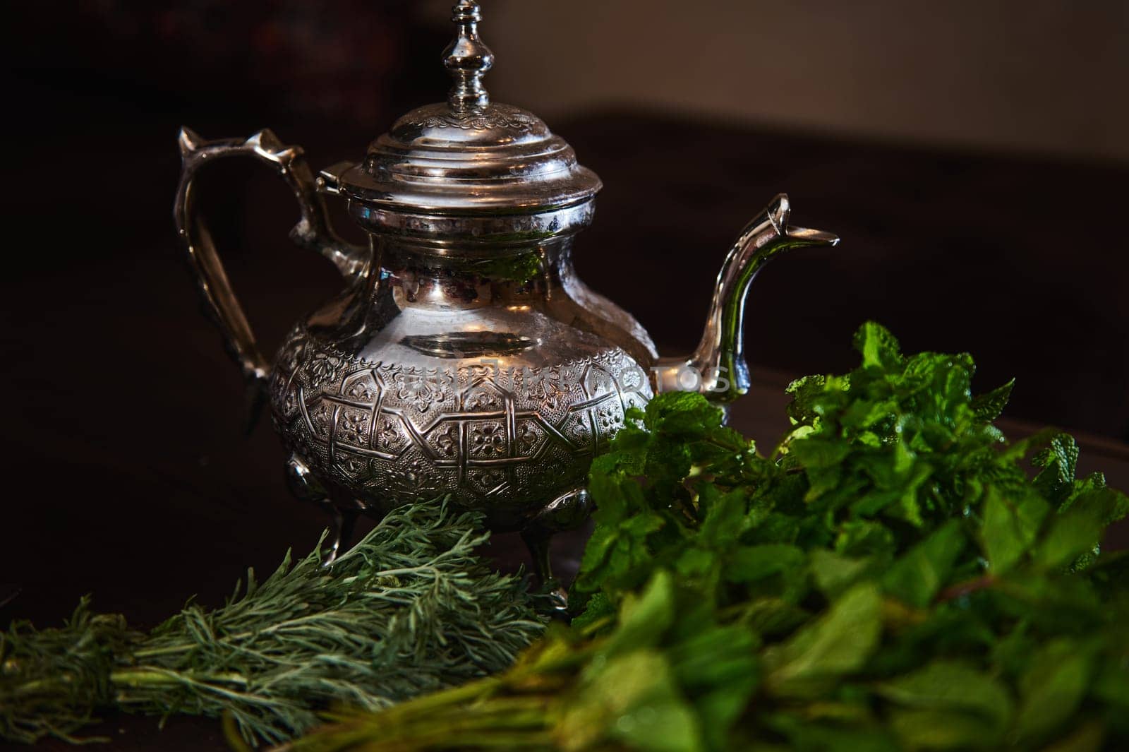 Silver teapot and bunch of mint. Traditional Moroccan tea as symbol of the hospitality of Moroccan people by artgf