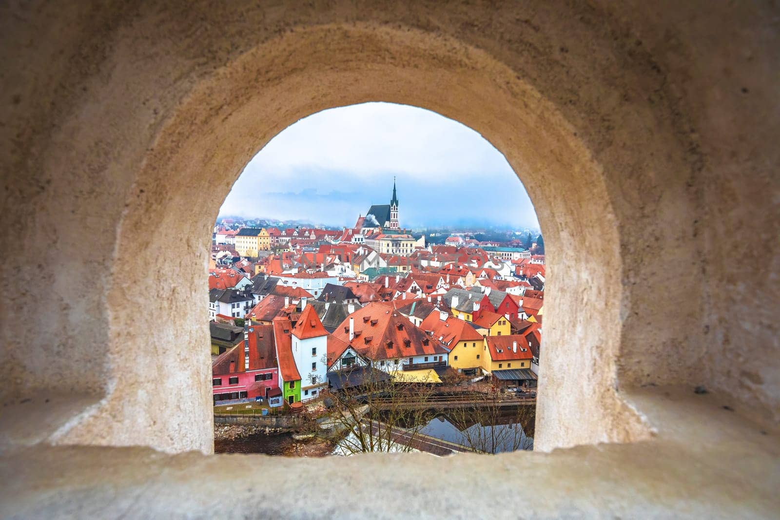 Town of Cesky Krumlov and Vltava river panoramic view through stone window by xbrchx