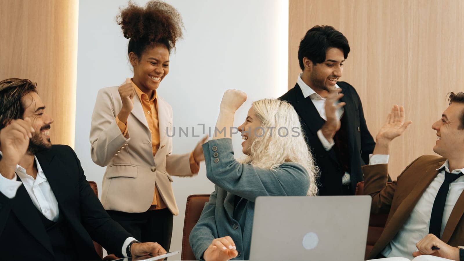 Diverse group of office worker and employee raise their hands up with happy and excited celebration for being good teamwork and positive attitude contribute to business success in ornamented workplace