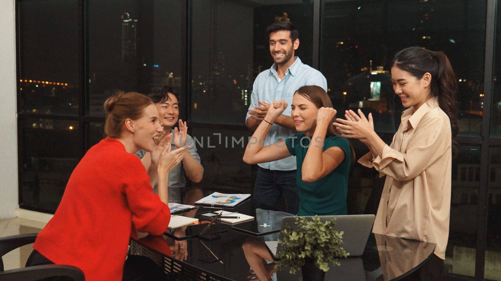 Businesspeople putting hands together and clapping hands to celebrate successful project at modern office with night city view. Group of manager with stacks of hands. Teamwork, trust. Tracery