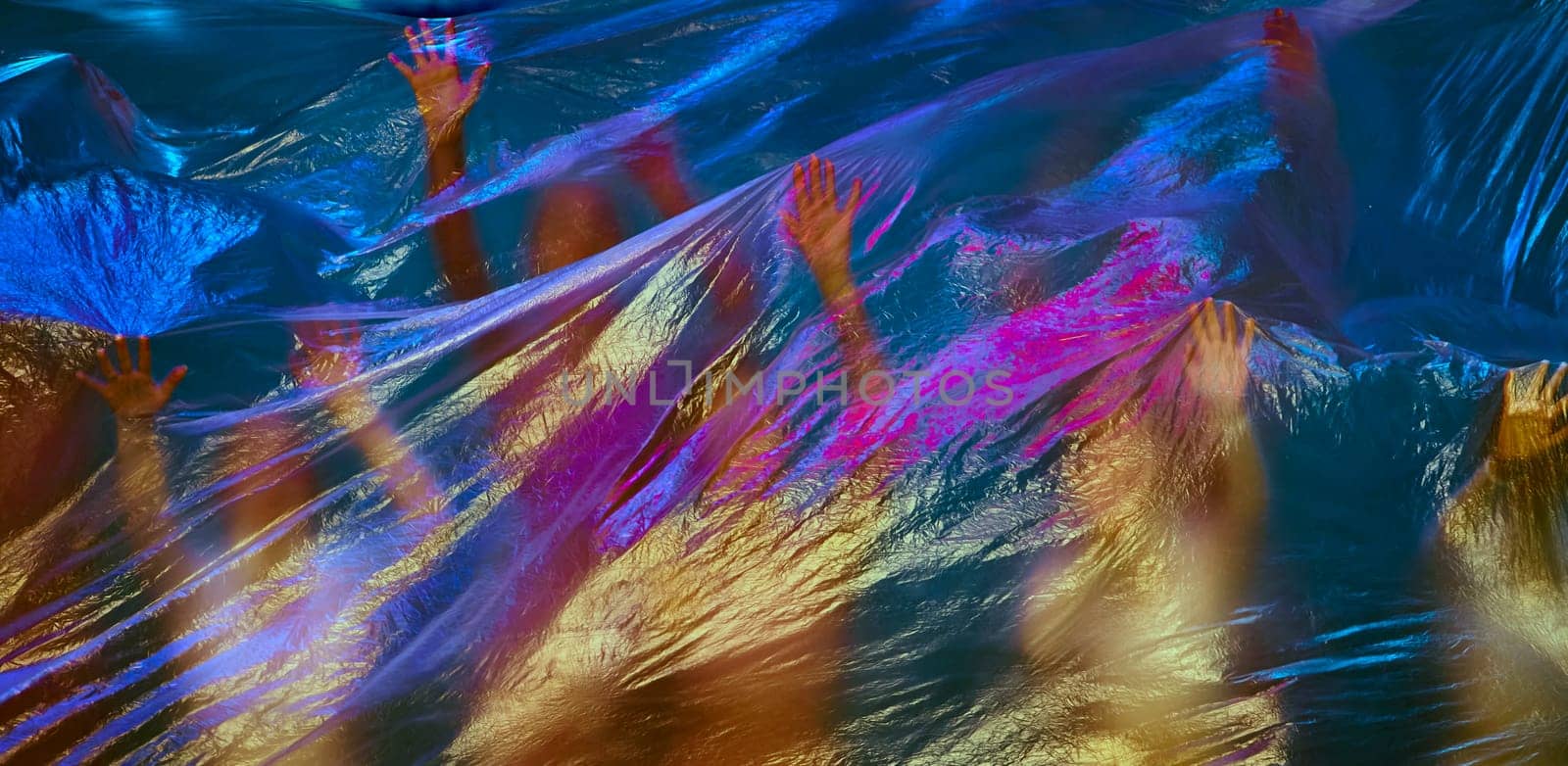 Talented dancers in pink leotards perform gracefully on stage behind a transparent curtain lit with a vibrant blue light, captivating the audience with their skill and artistry.