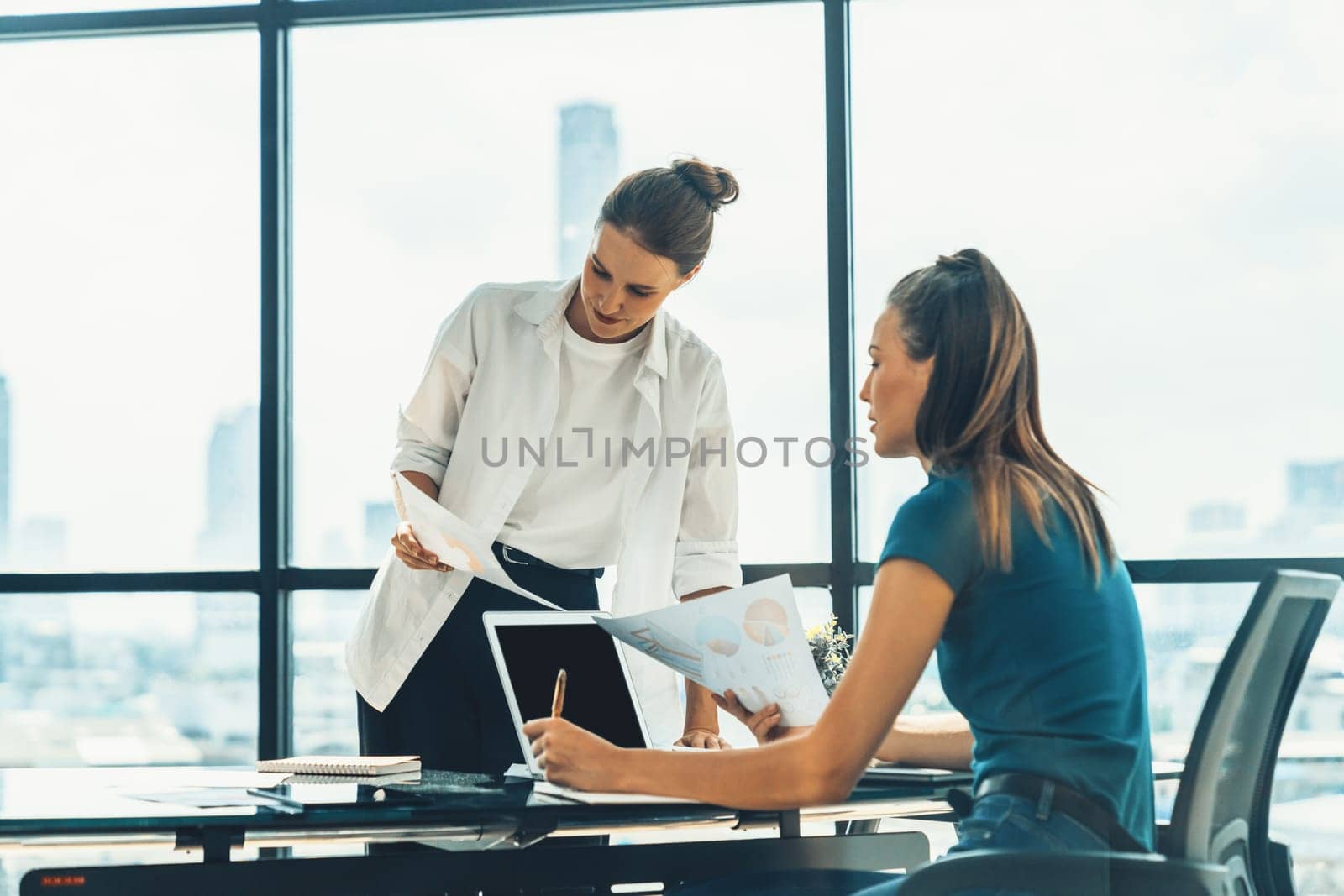 Professional businesswoman discuss about financial plan by using statistic document. Group of businesspeople brainstorming and sharing idea at modern office. Working together and business. Tracery.