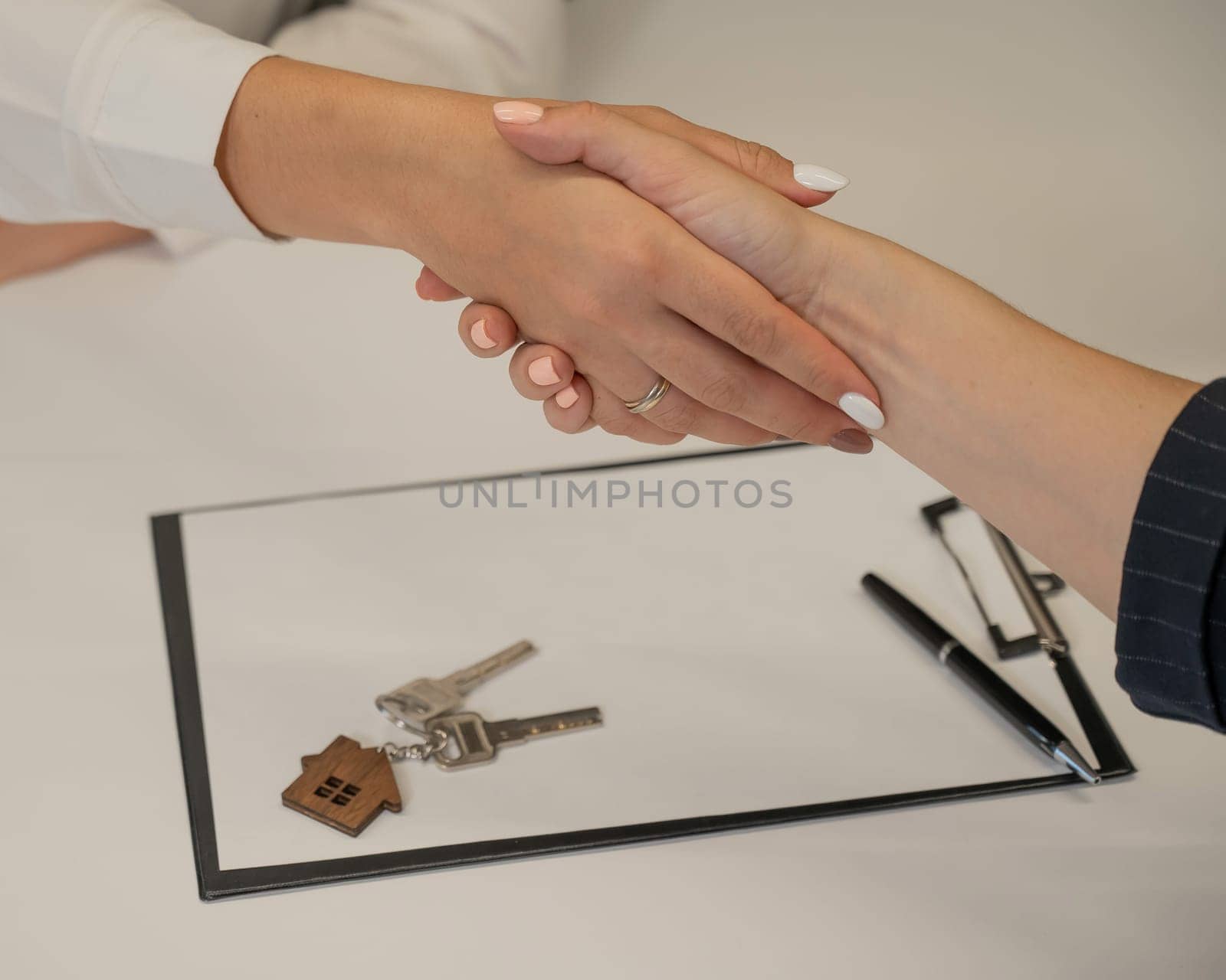 Real estate purchase transaction. Realtor and buyer shaking hands