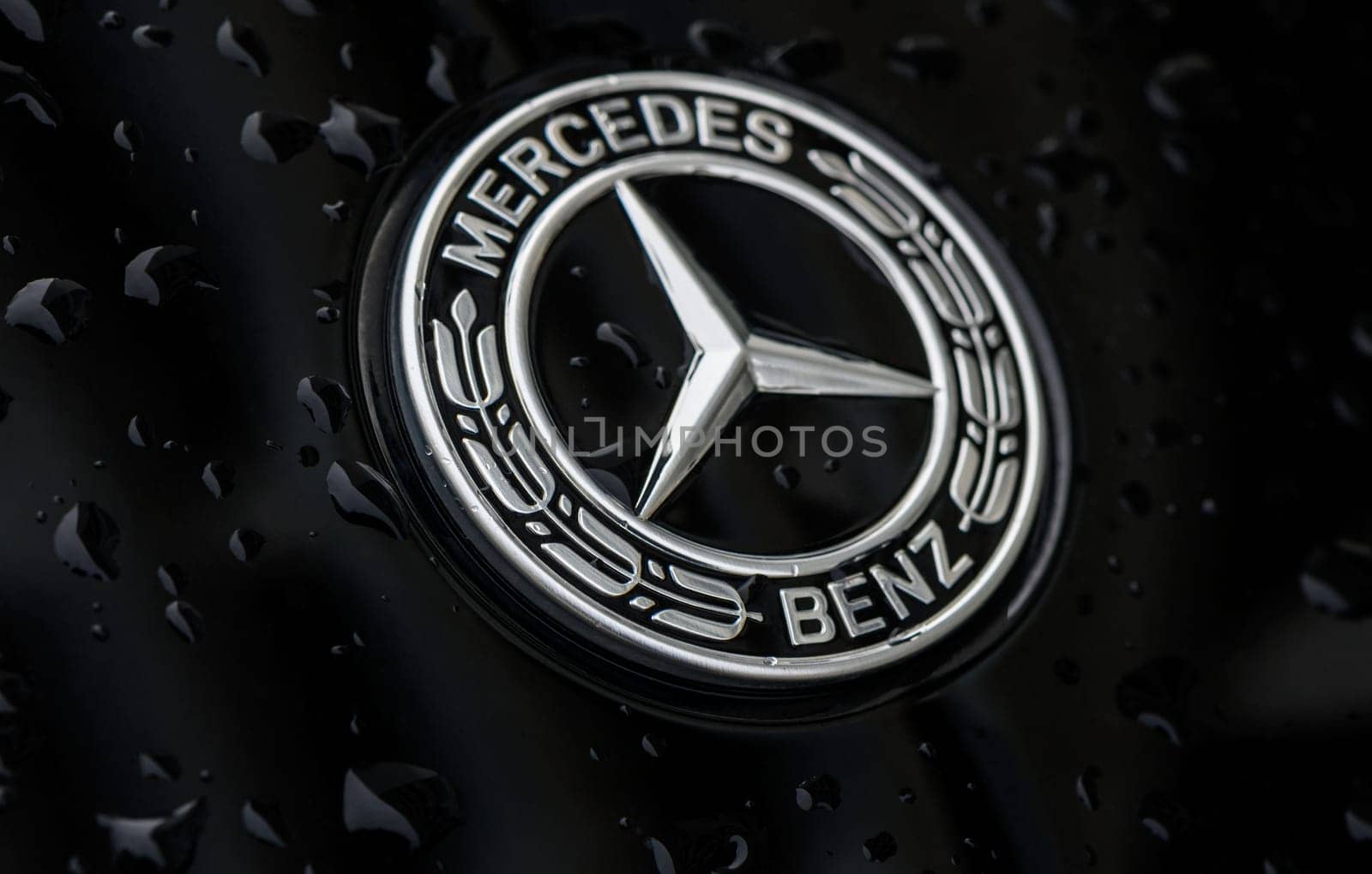 Chernigov Ukraine 13.03.2024-Close-up of the blue round Mercedes Benz logo on the hood of a black car. by Mixa74