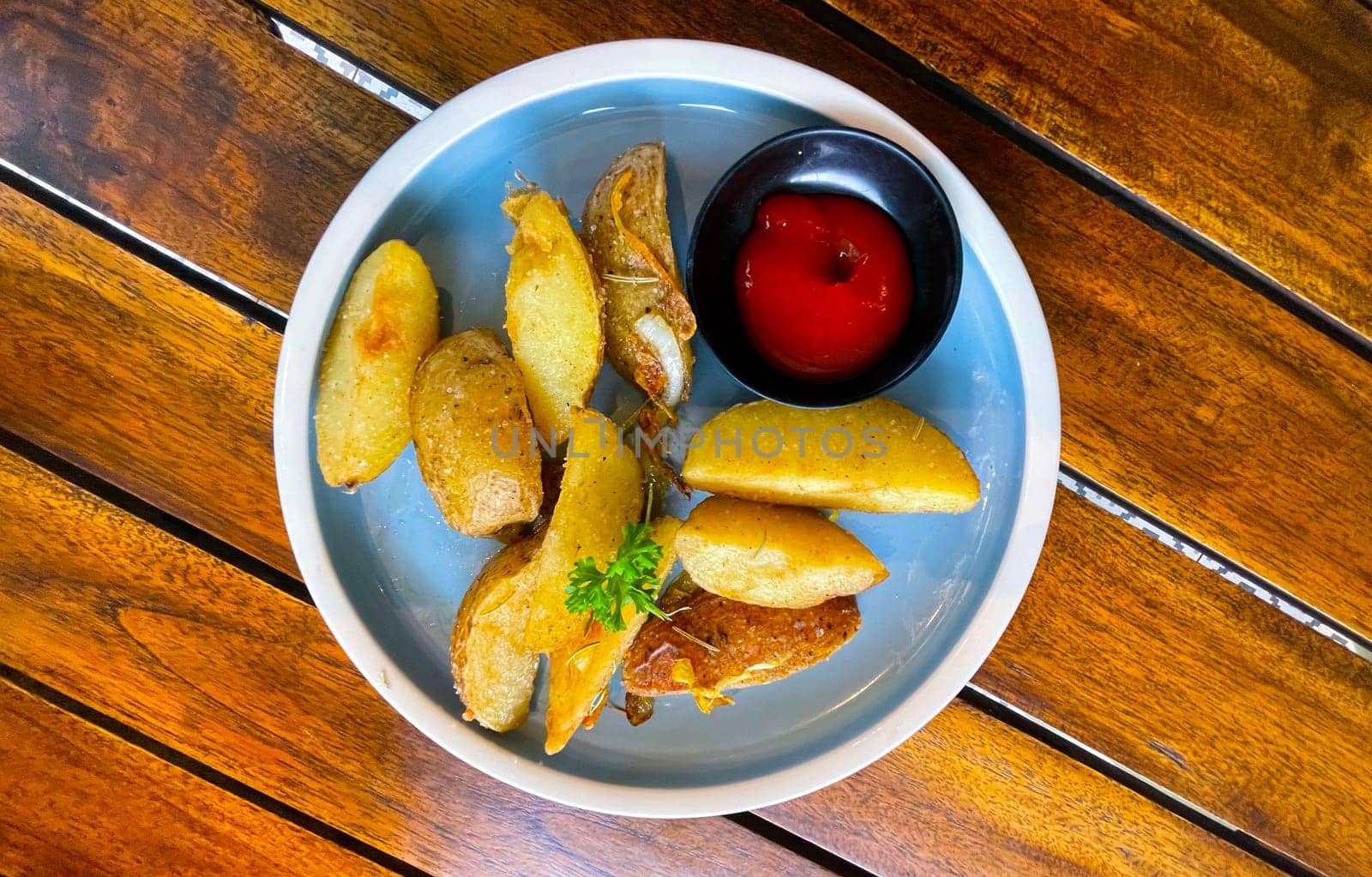 Baked potato wedges with shredded onion and herbs and tomato sauce platted homemade organic vegetable vegan vegetarian potato wedges snack food meal