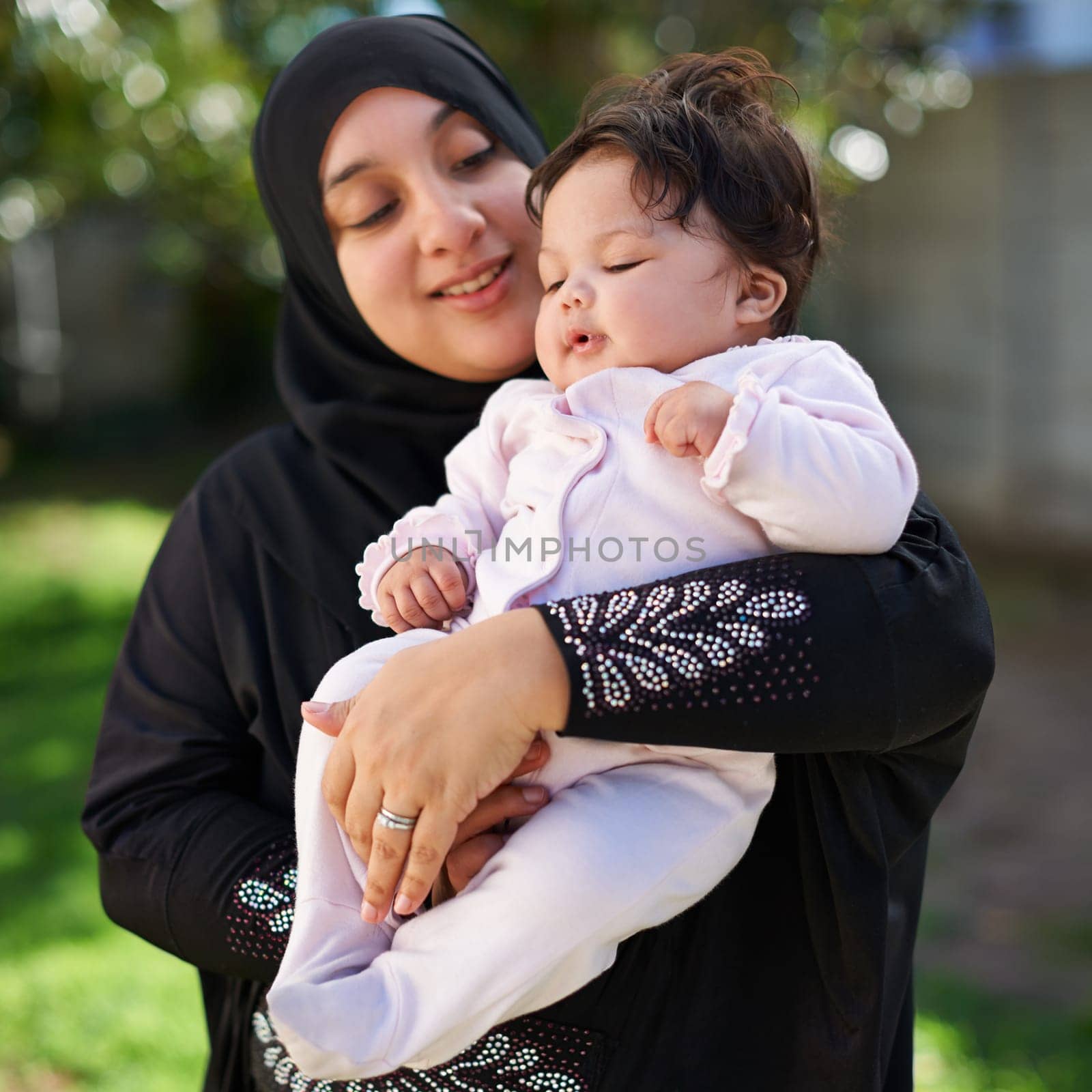 Muslim, woman and baby cuddle outdoor, happy in garden with mother and child for Eid celebration. Motherhood, family and Islamic holiday with hijab, infant and hug with smile in backyard for bonding.