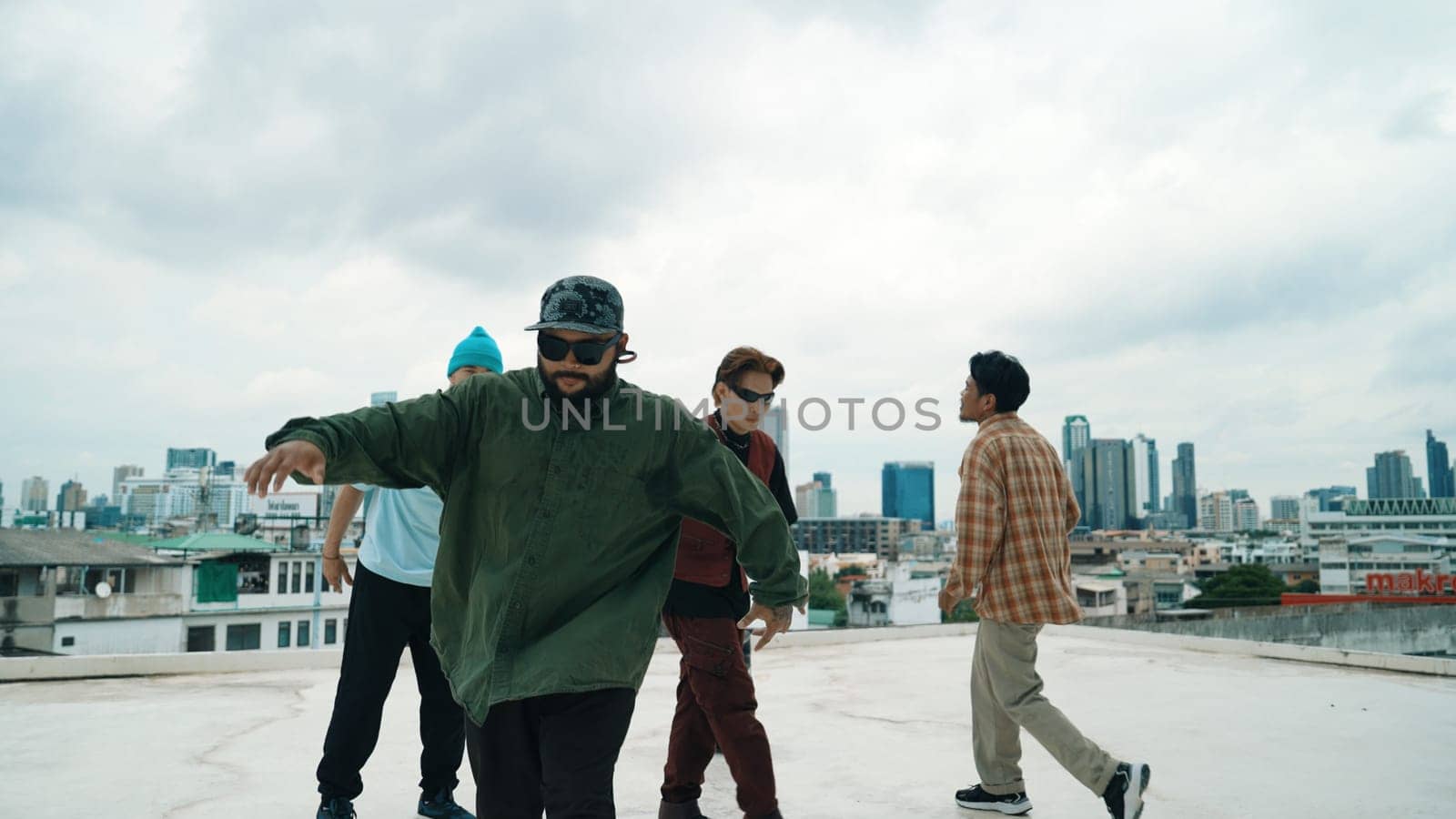 Professional break dance team practice B-boy dance while multicultural friends at rooftop. Young modern dancing group doing hip hop movement. Style,fashion,action. Outdoor sport 2024. Endeavor.