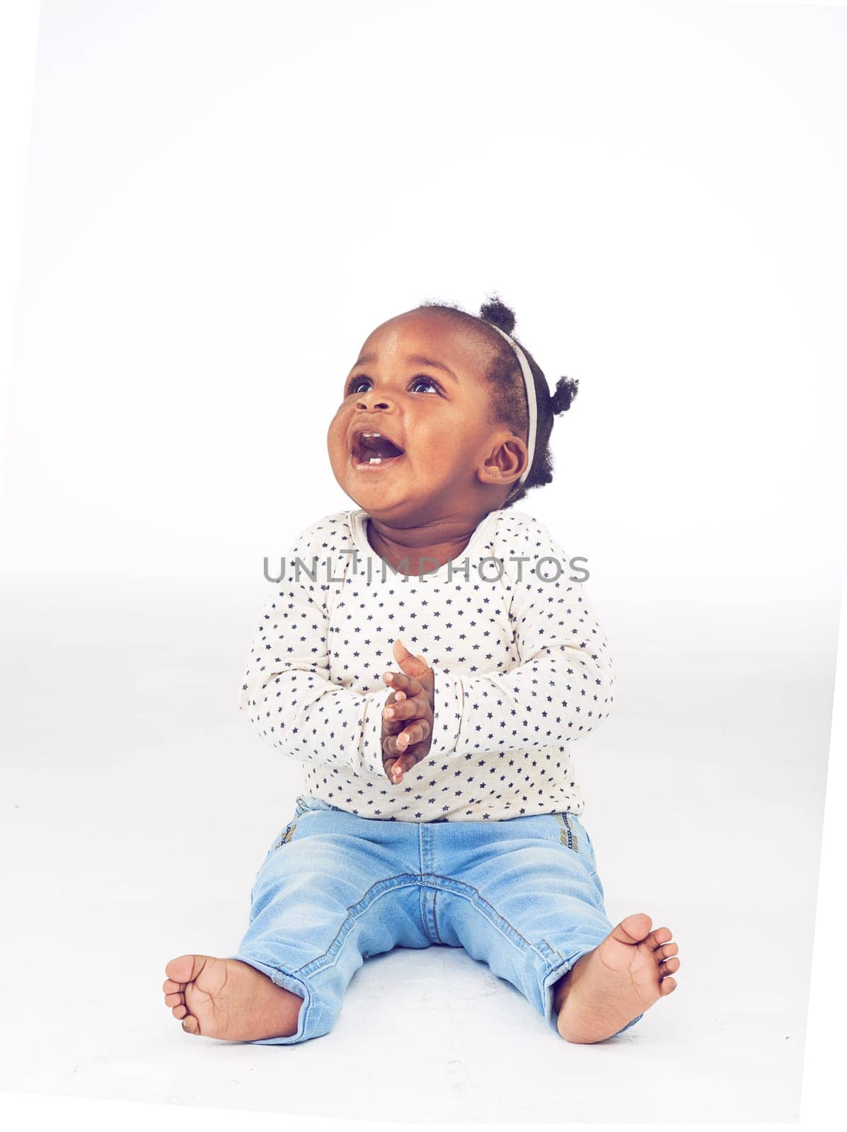 Black baby, girl or excited to relax, laugh or vision for clapping, funny or idea on white background. Toddler, smile or on floor to imagine, curiosity or wonder of childhood on studio mock up by YuriArcurs