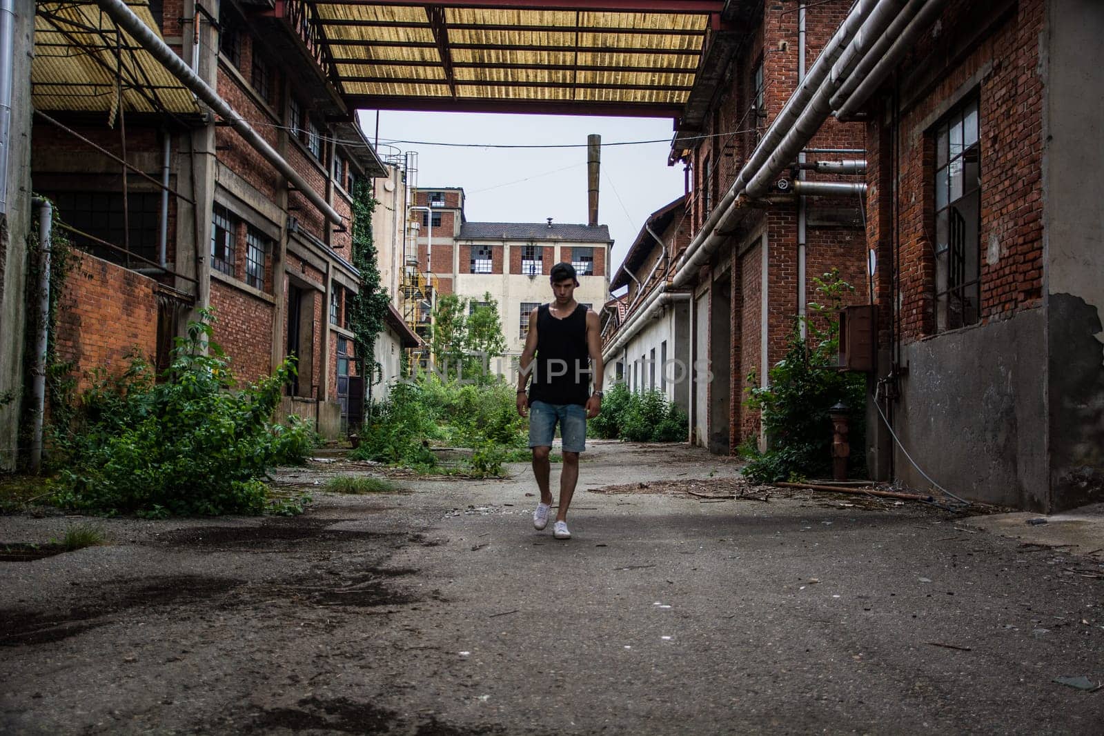 A man in a tank top standing in a factory