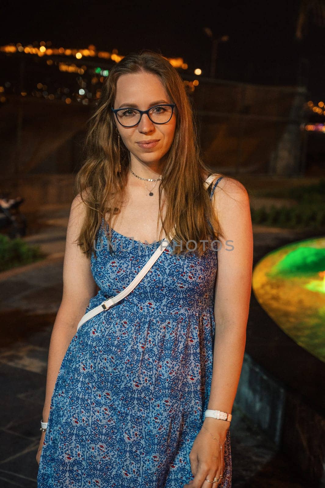 Woman on light and colour fountain background in night city Alanya, Turkey in 2023.