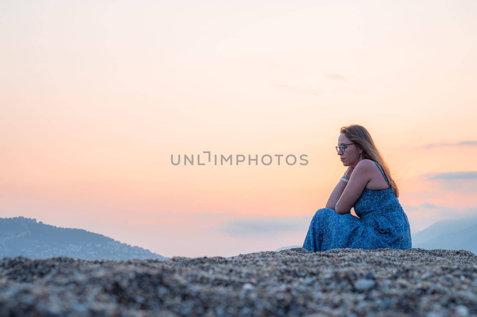 Woman sits on the beach and looks at the sea in Alanya city, Turkey. Travelling or vacation concept