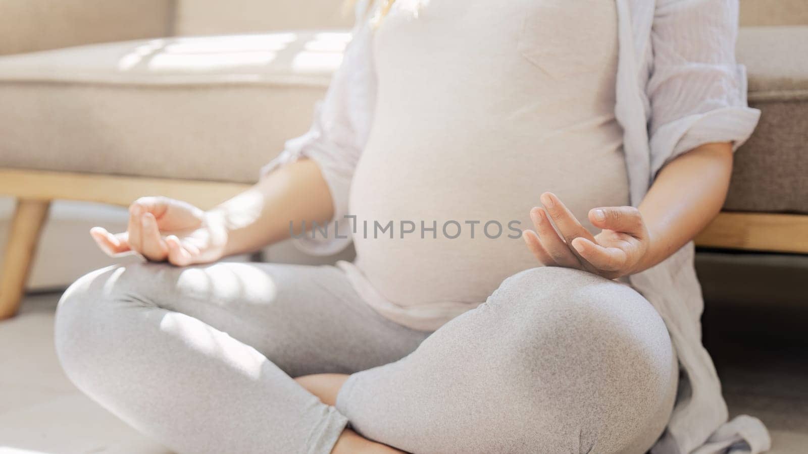 Healthy Pregnancy Yoga and Fitness. Young pregnant yoga woman and meditation in living room.