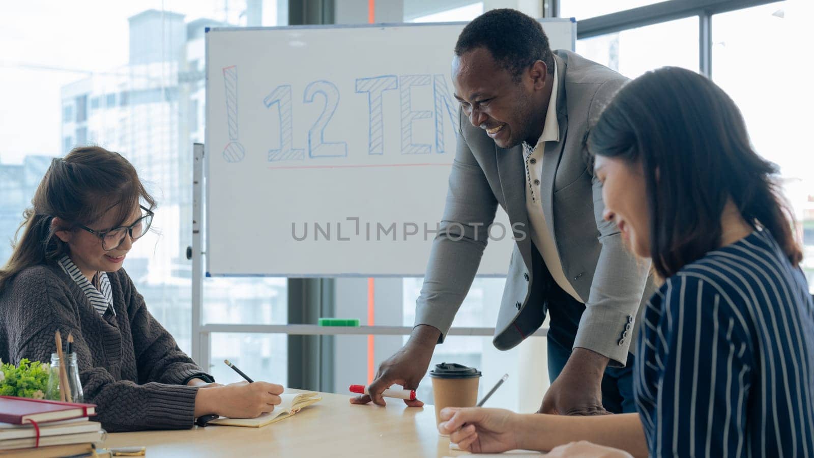 Mature professor talking to his student while assisting her on a class at the university..