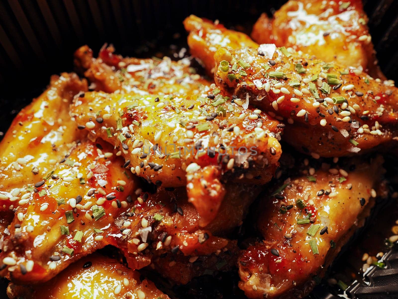 Macro close-up with Korean Chicken wings with sauce. 치킨. Traditional oriental food.