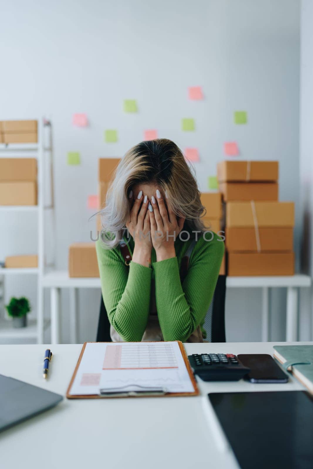 Starting small business entrepreneur of independent Asian woman showing her face worried about the sales of her business not reaching the target set. SME concepts by Manastrong
