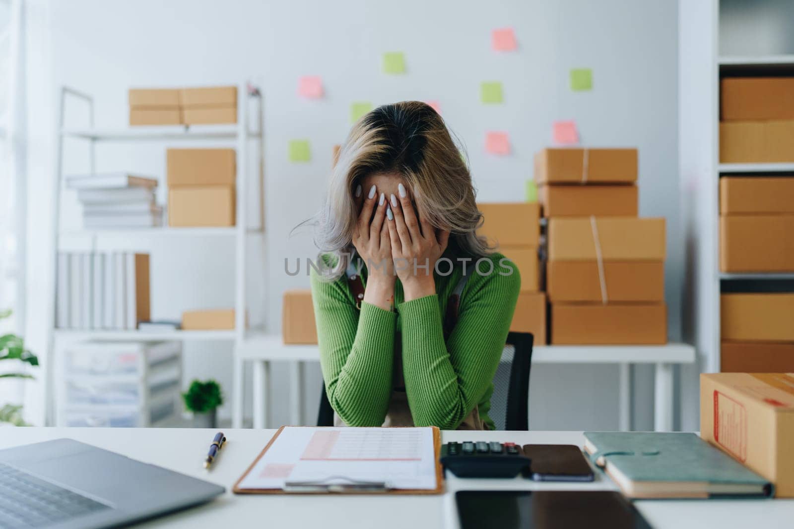 Starting small business entrepreneur of independent Asian woman showing her face worried about the sales of her business not reaching the target set. SME concepts.