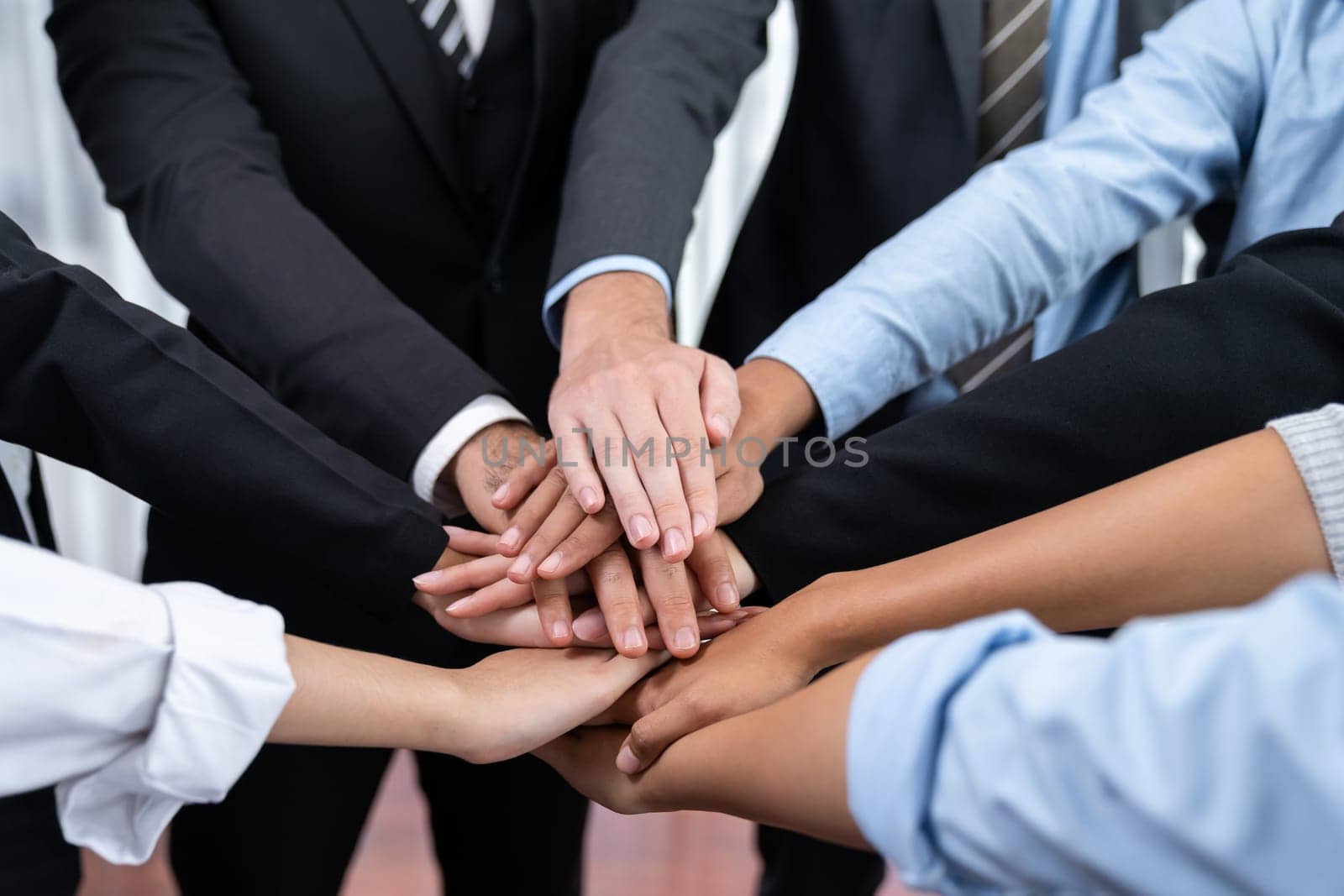 Multiracial business people make synergy hand stack together in meeting room as cooperation or team building for corporate employee in workplace. Meticulous