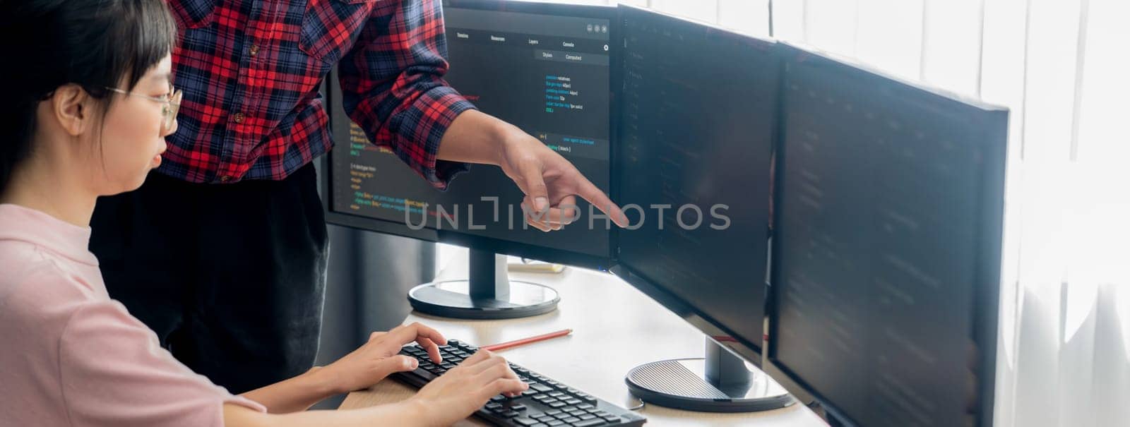 Cropped image of professional programer team collaboration discuss about web coding while coworker point java script displayed on computer at modern company office. Closeup. Burgeoning.