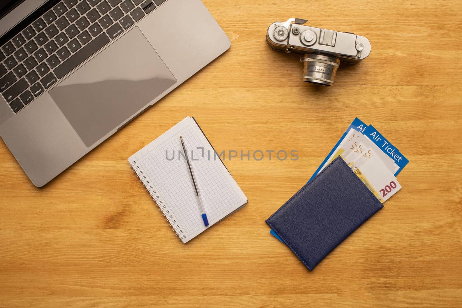 Top view off office photography desk table with laptop, notebook, camera and passport with air ticket.