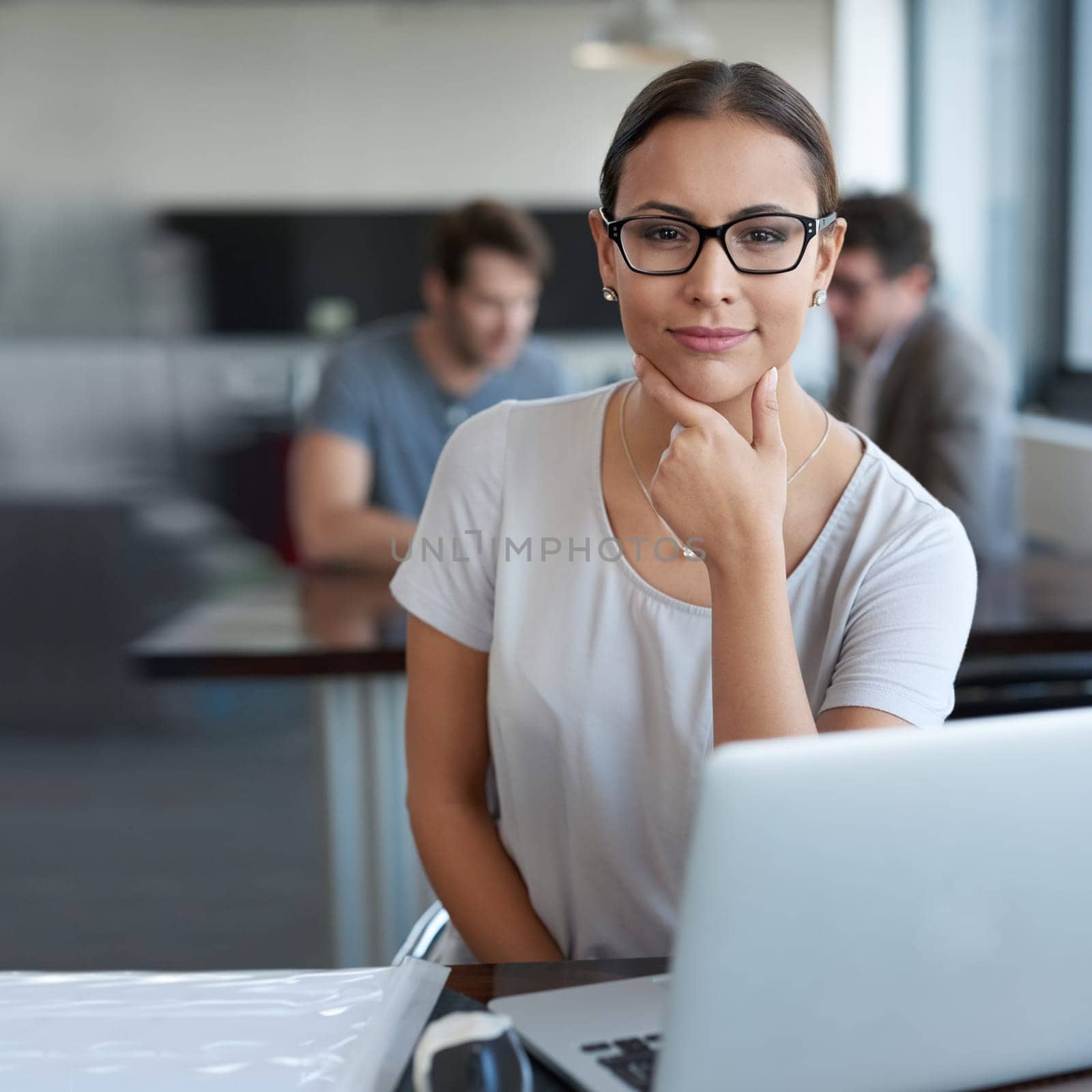 Portrait, thinking and business woman on laptop at table in office for creative career or job in startup. Face, computer and professional entrepreneur planning, employee and copywriter with glasses.