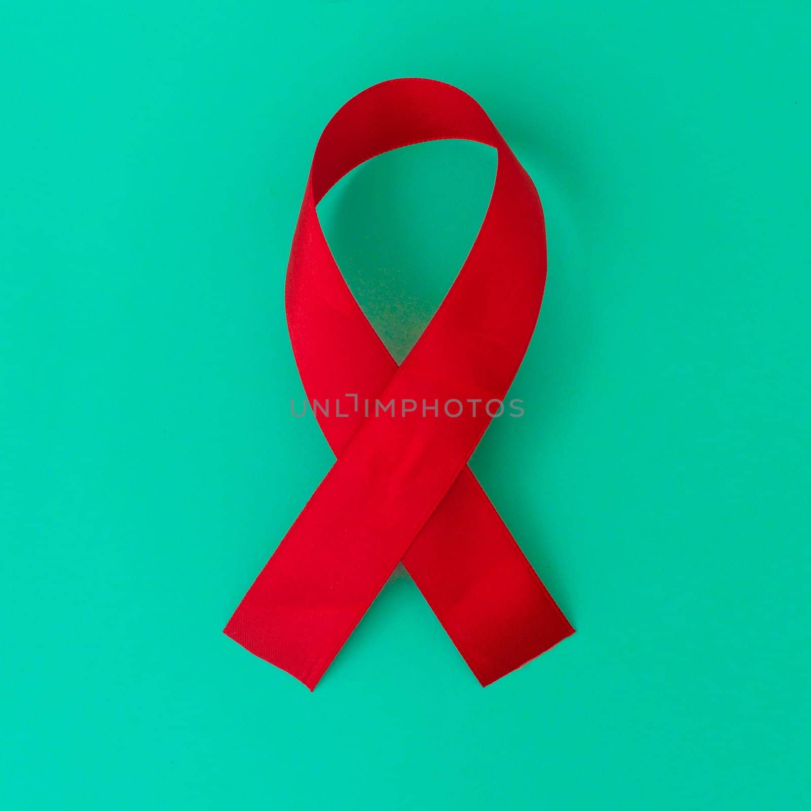 Red color ribbon isolated awareness on blue background for World aids day campaign.