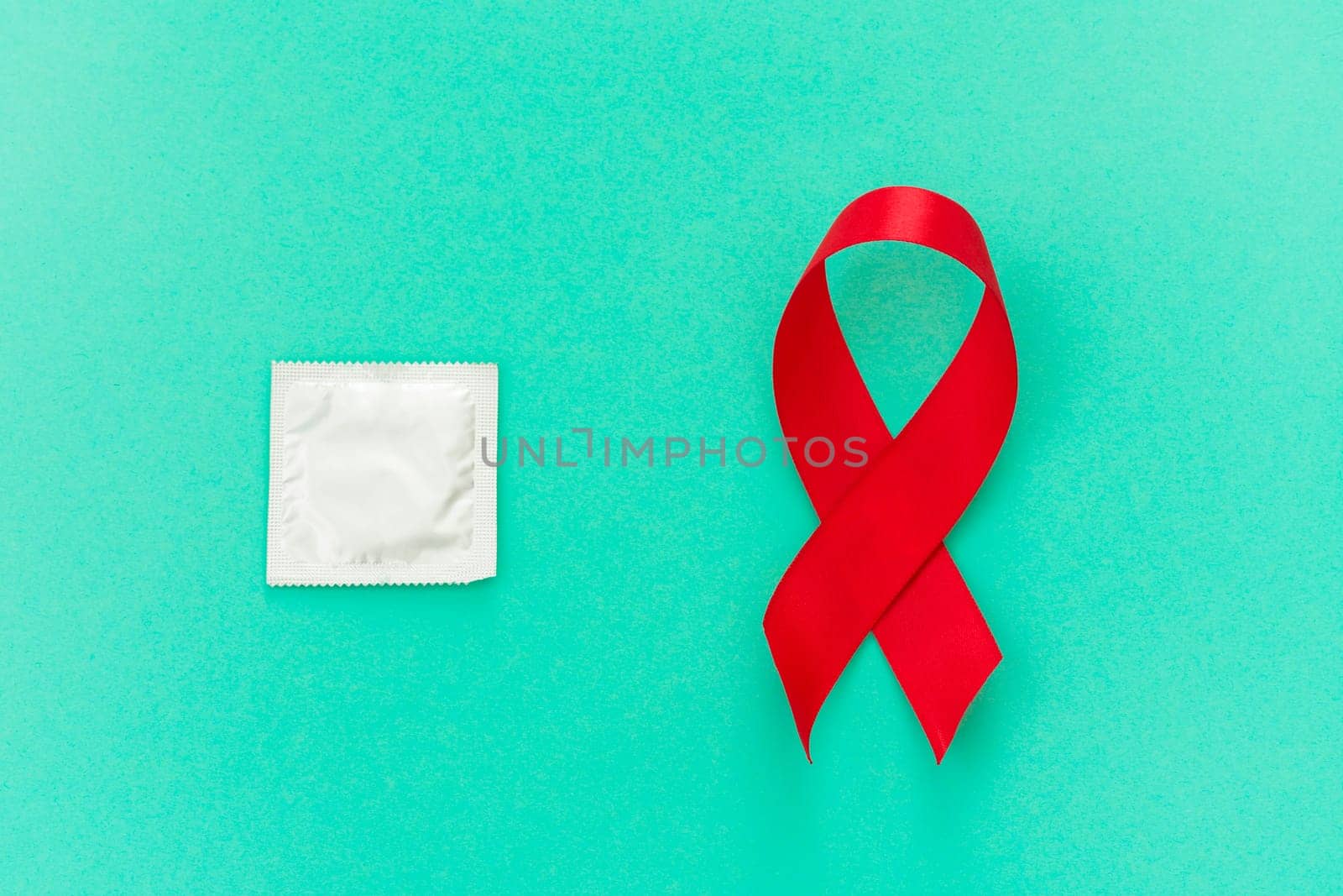 Red ribbon with a condom on a blue background by zartarn