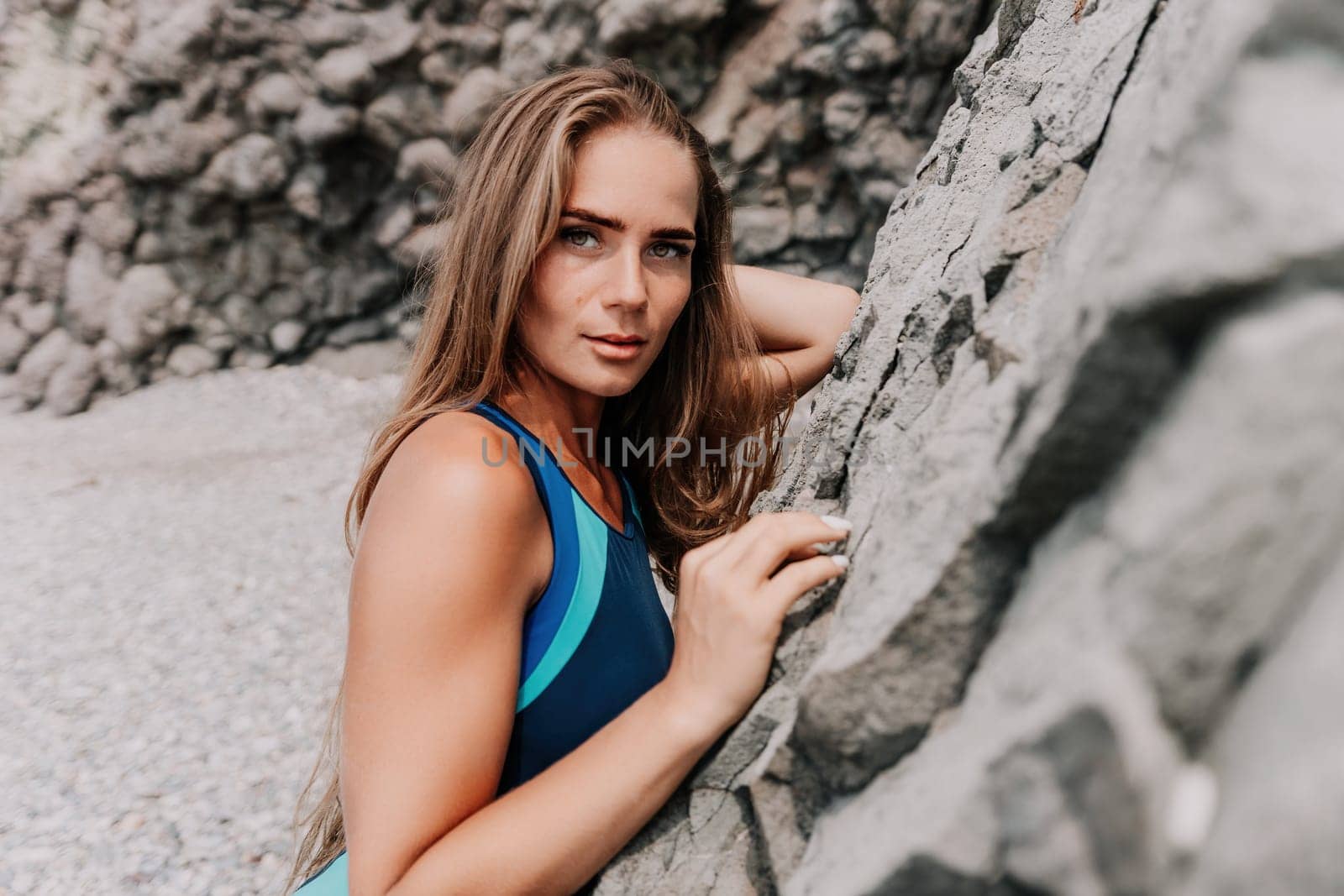 Woman summer travel sea. Happy tourist in blue bikini enjoy taking picture outdoors for memories. Woman traveler posing on the beach surrounded by volcanic mountains, sharing travel adventure journey by panophotograph