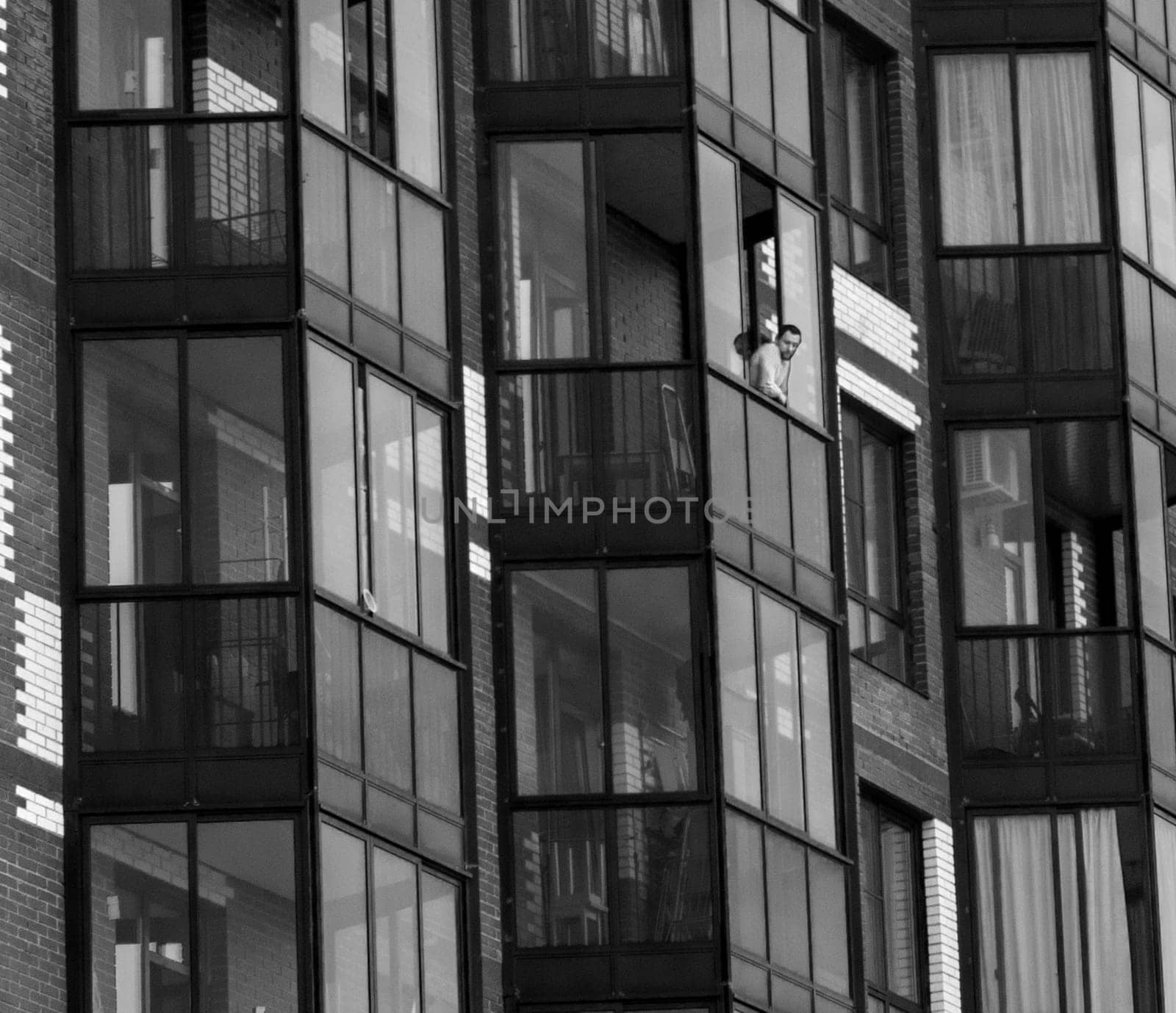Moscow, Russia - 07.03.2023 - Shot of the man looking from the balcony of his apartment