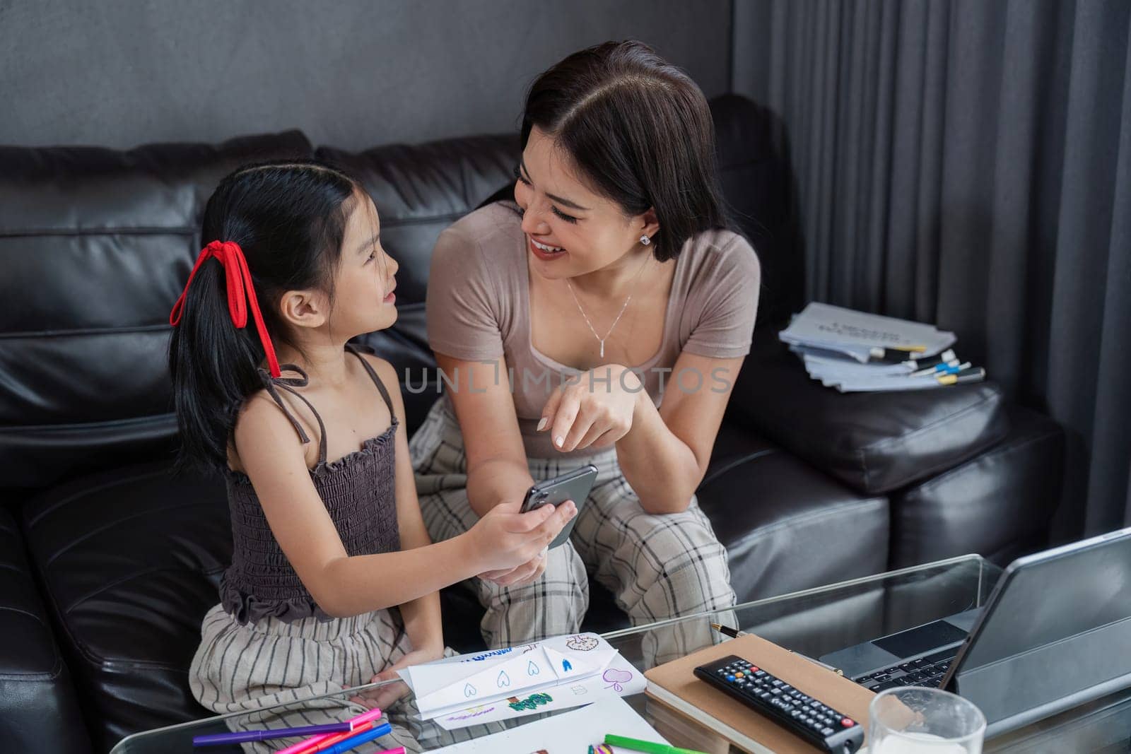 business woman work from home and take care of her child while working, doing activities with her child while working.