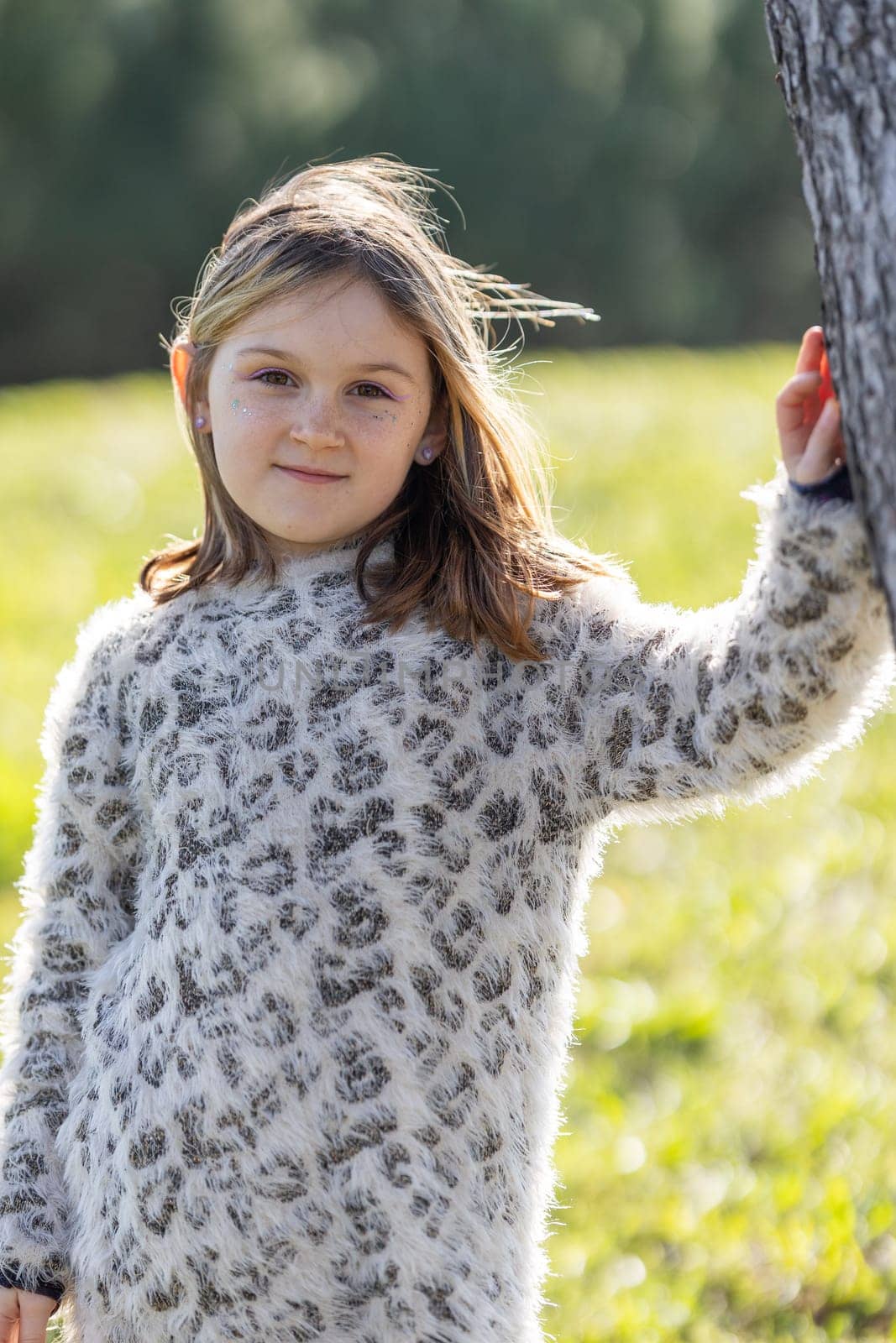 Beautiful little girl 7 years old in the summer park - portrait near tree