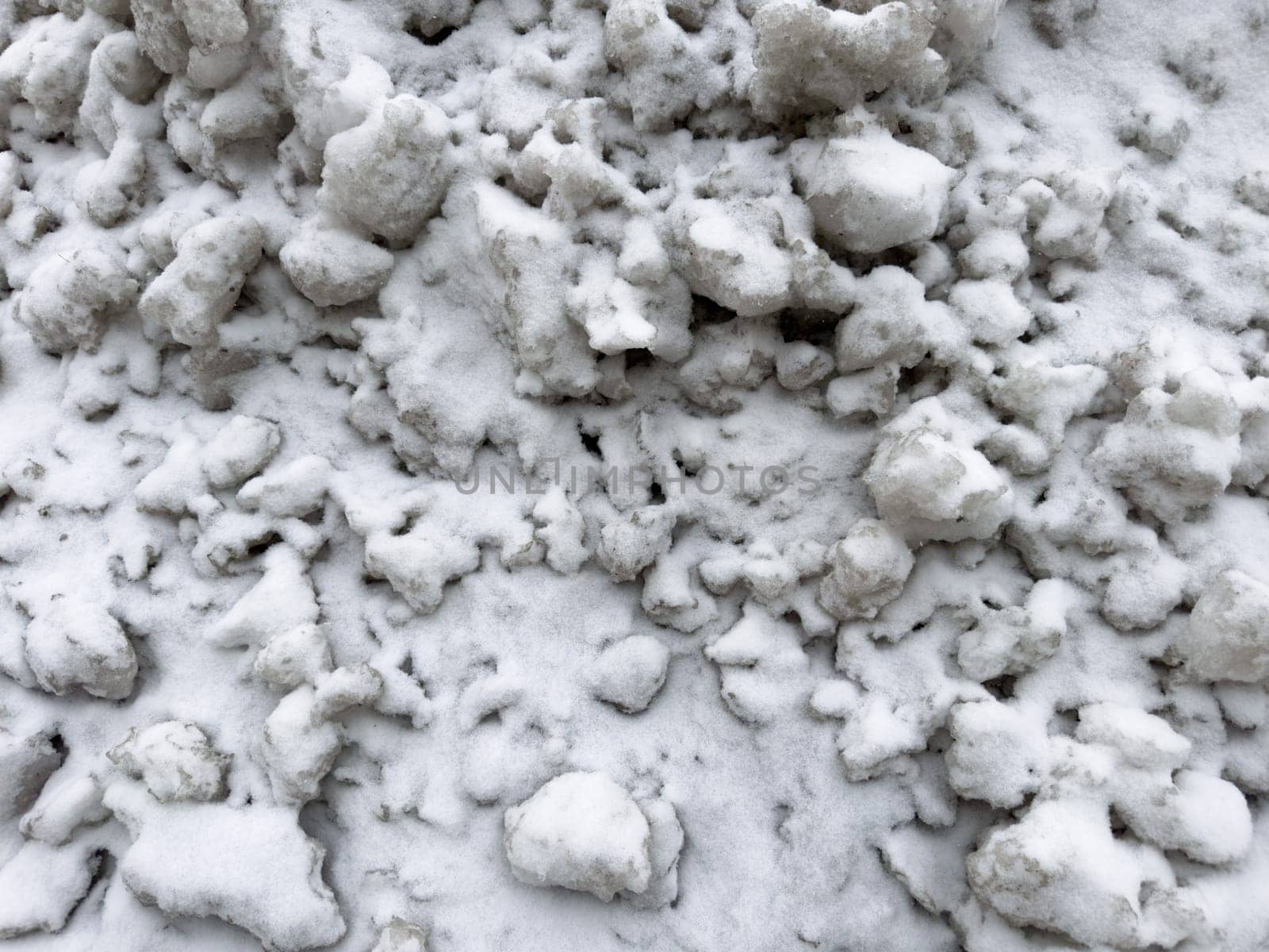 texture pieces of white snow lie on the road