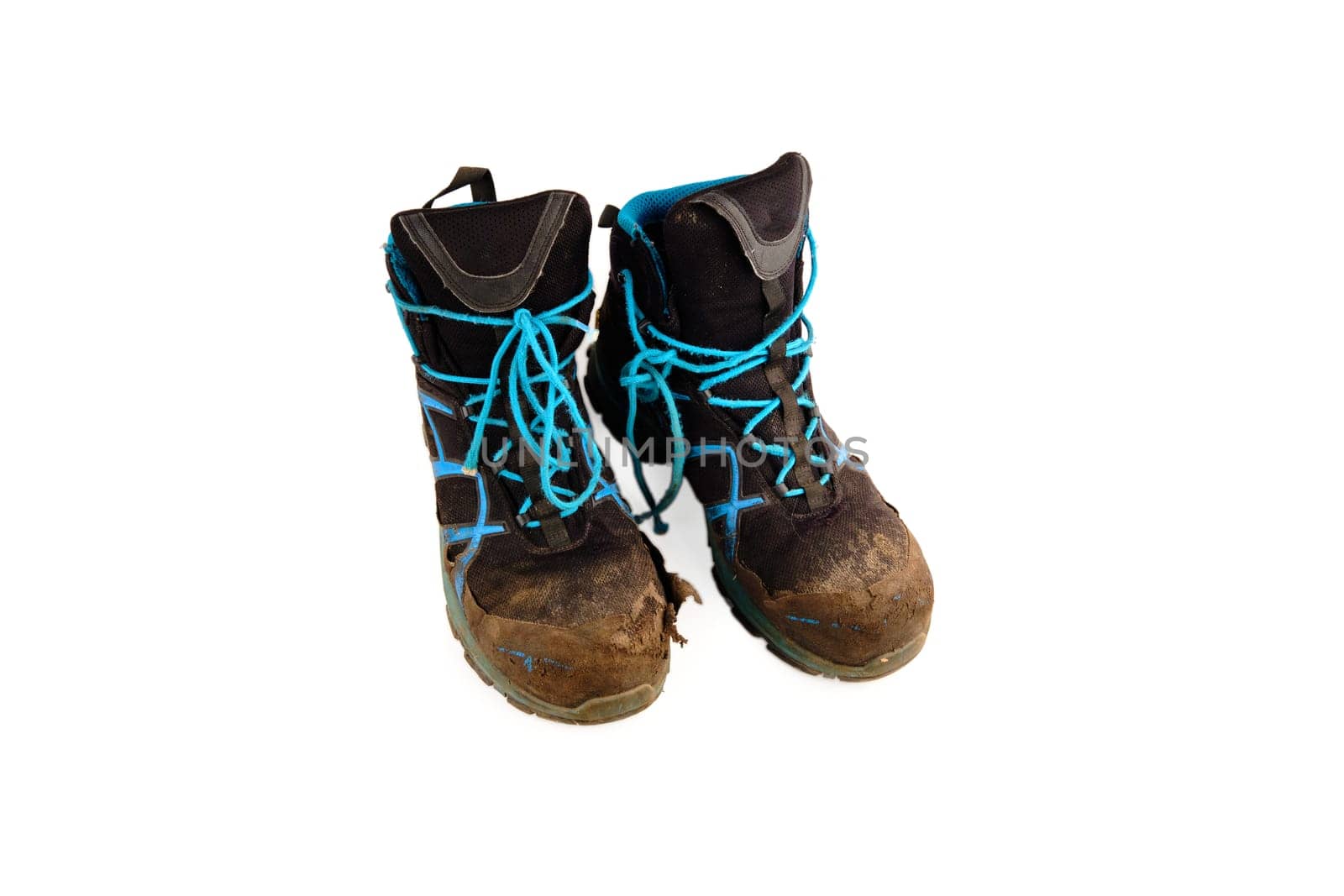 Dirty worn sports shoes after hiking in difficult conditions