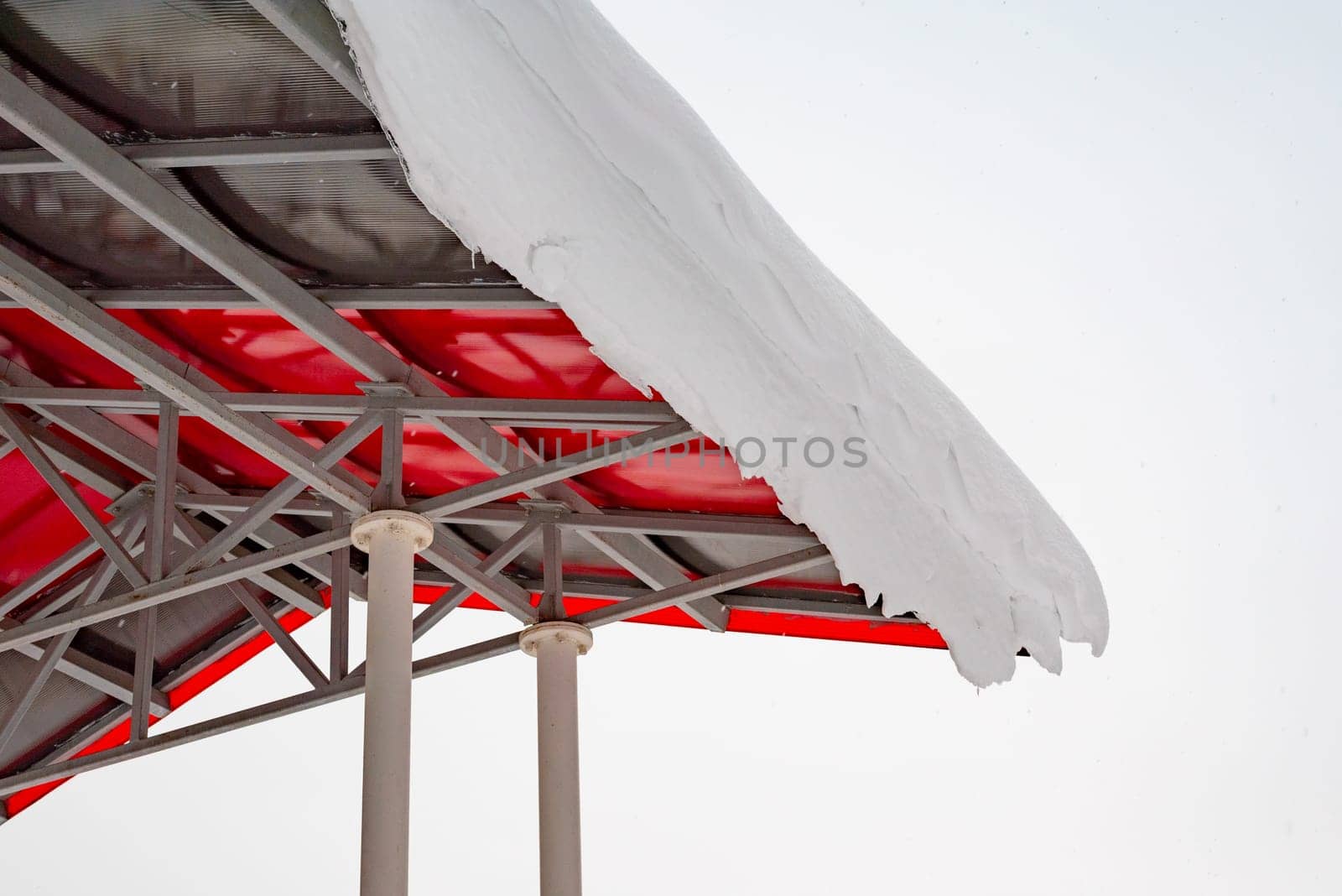 Internal structural elements of an iron roof. Snow on the edge