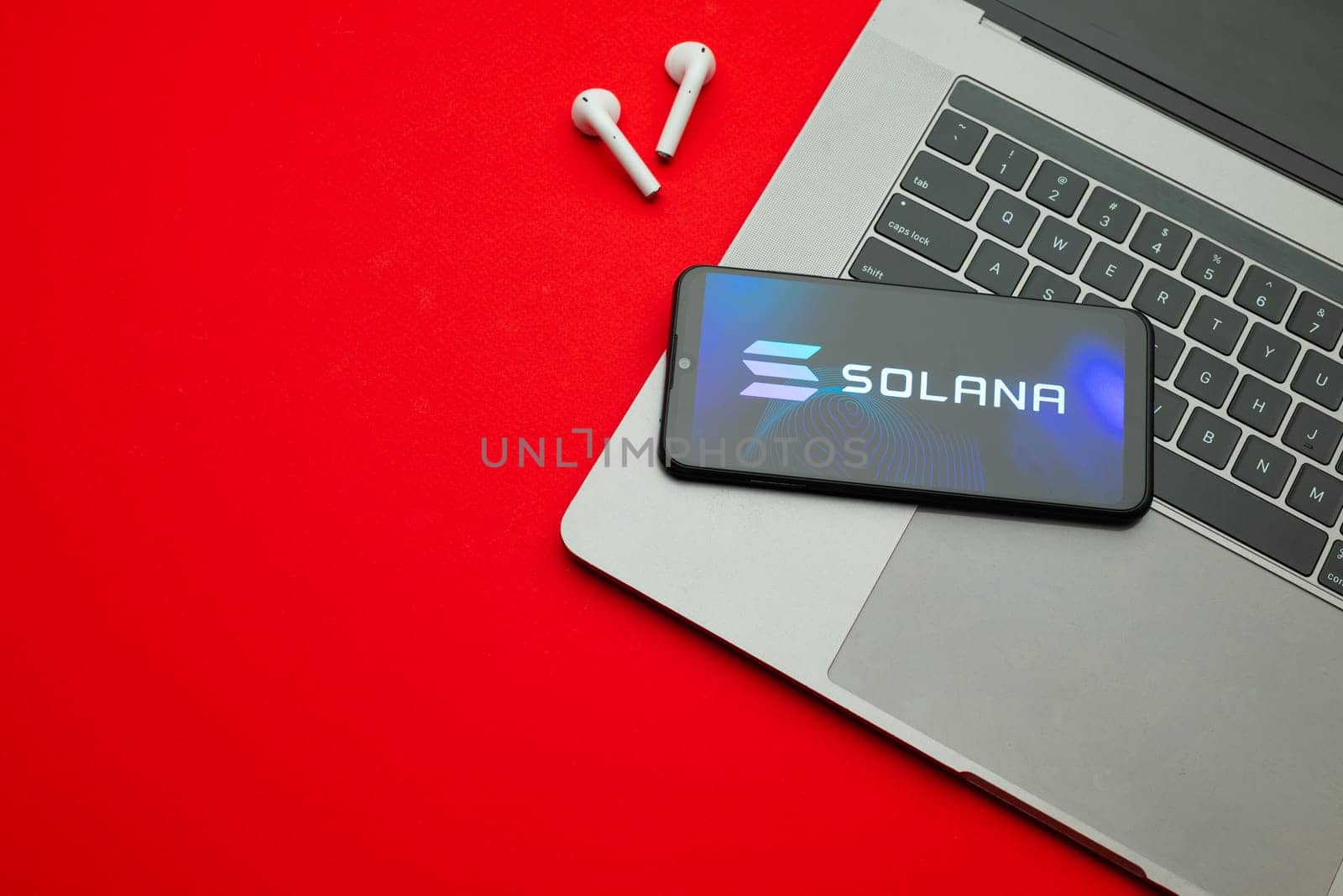 Tula, Russia - Jan 10, 2022: Solana logo on smartphone screen on red background. by zartarn