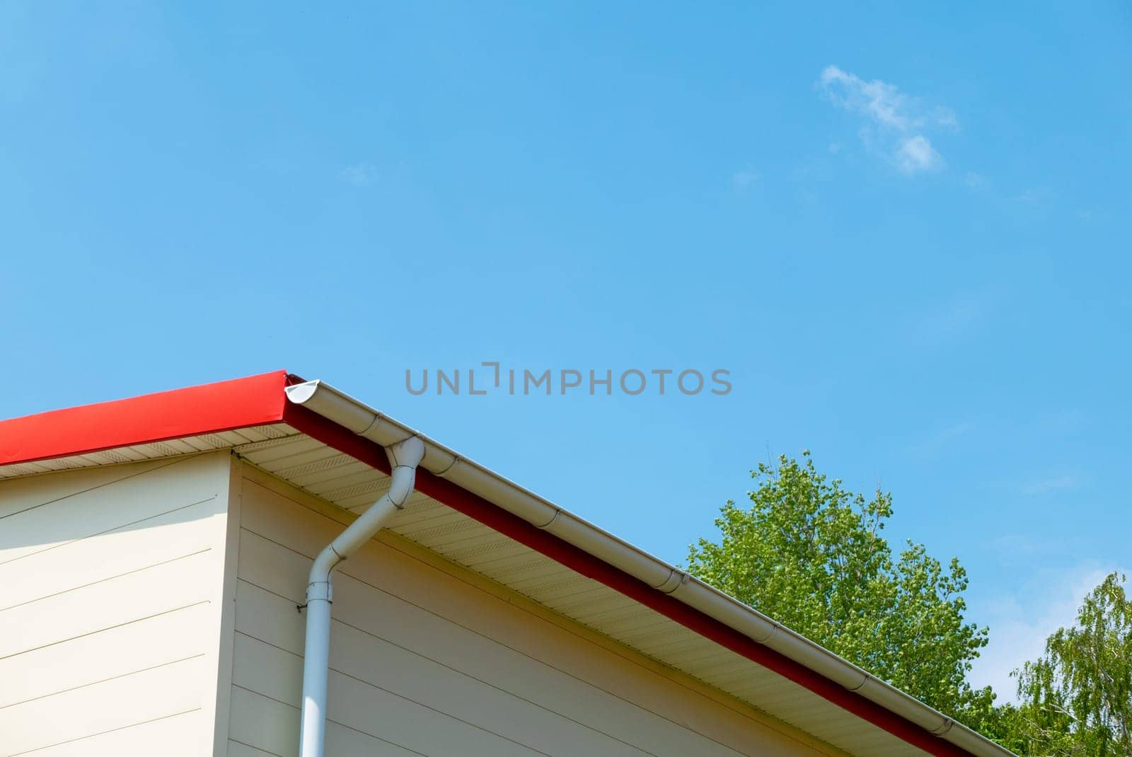 Red gutter on the roof top of house.