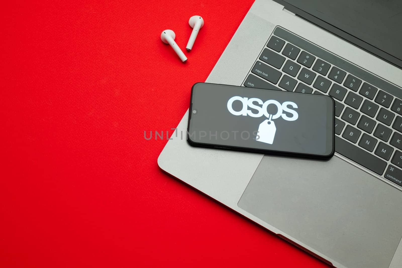 Tula, Russia - Jan 10, 2022: ASOS logo on smartphone screen on red background.