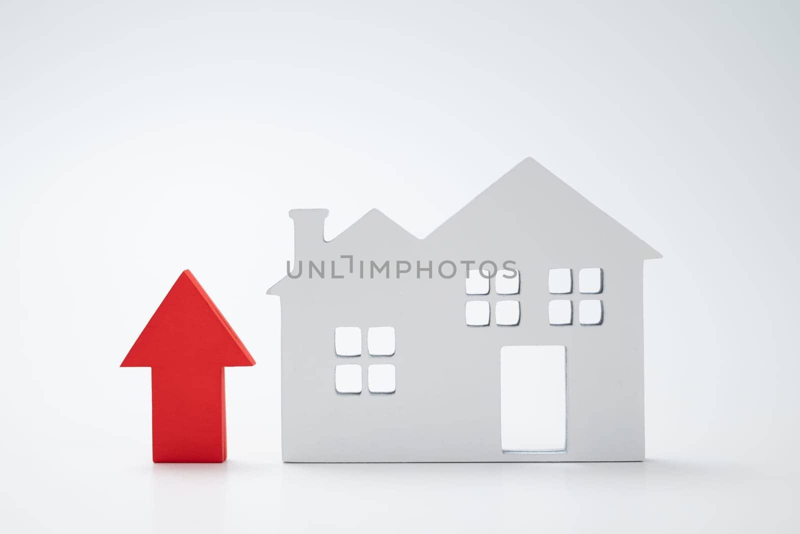 a red up arrow and house. The concept of the rising price of real estate by zartarn