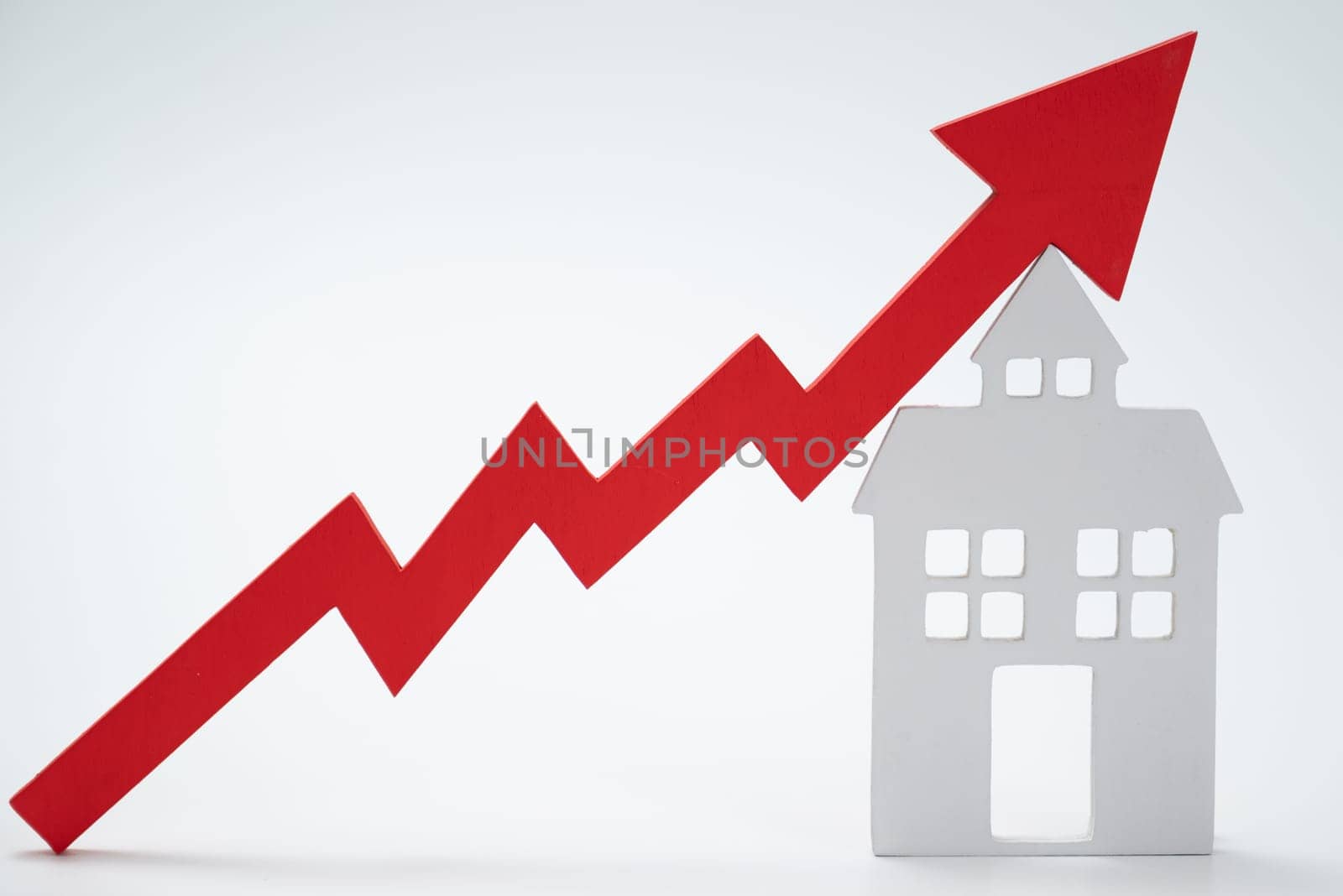 a red up arrow and house. The concept of the rising price of real estate