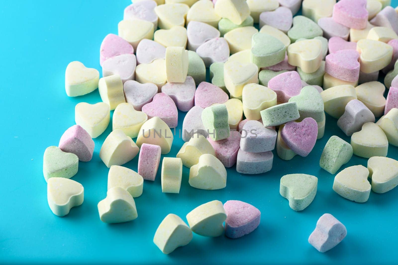 Delicious heart shaped candies on white table, closeup by Mixa74