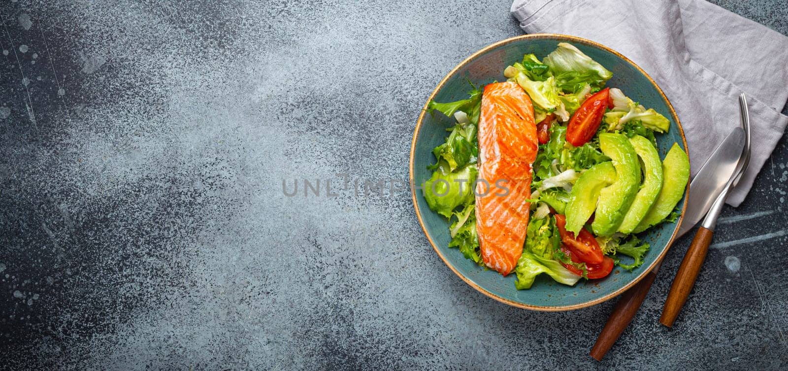 Grilled fish salmon steak and vegetables salad with avocado on ceramic plate on rustic stone background top view, balanced diet, healthy nutrition salad meal with salmon and veggies, space for text by its_al_dente