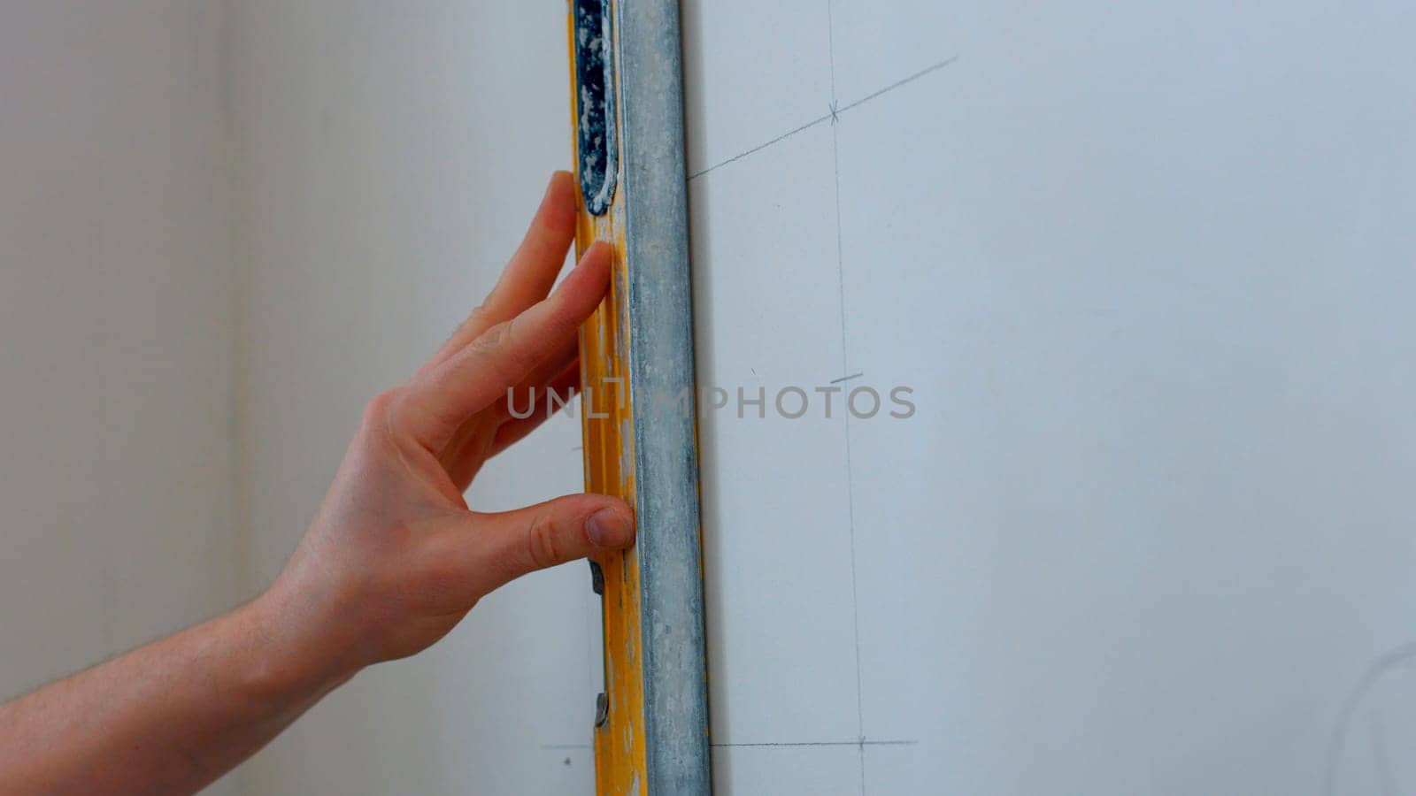 A specialist draws markings on the wall. Lines are drawn for future fastening.