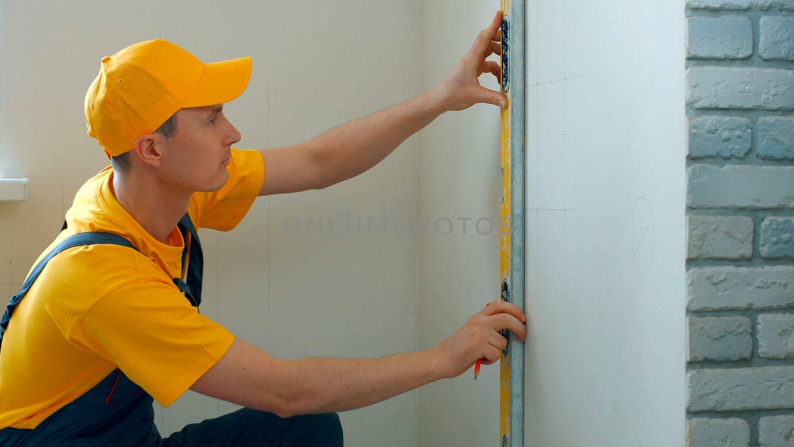 Engineer draws scheme on the wall. Builder making measurements on a white wall.