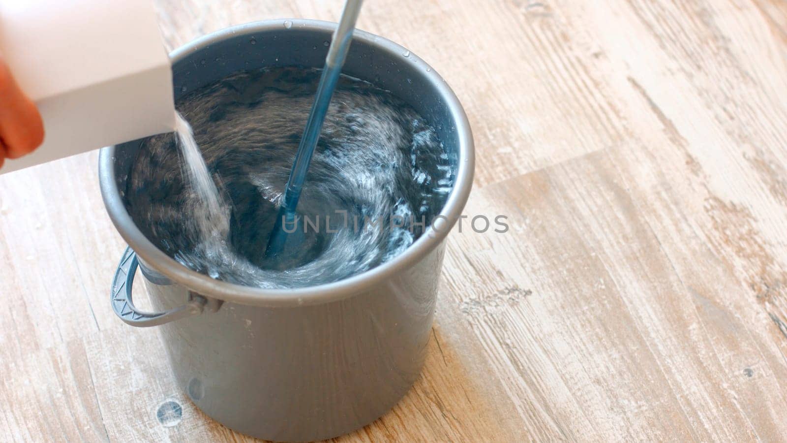 Preparation of construction glue for wallpaper. Mixing glue with water using a mixer.