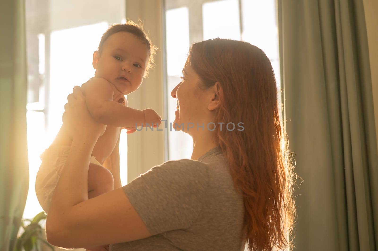 Caucasian woman gently lifts up her newborn son. by mrwed54