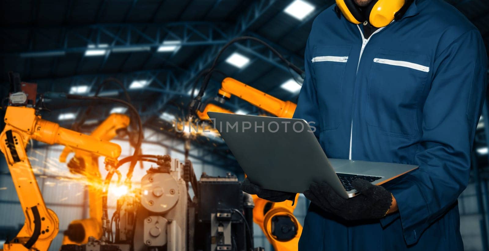 XAI Engineer use advanced robotic software to control industry robot arm in factory. Automation manufacturing process controlled by specialist using IOT software connected to internet network.