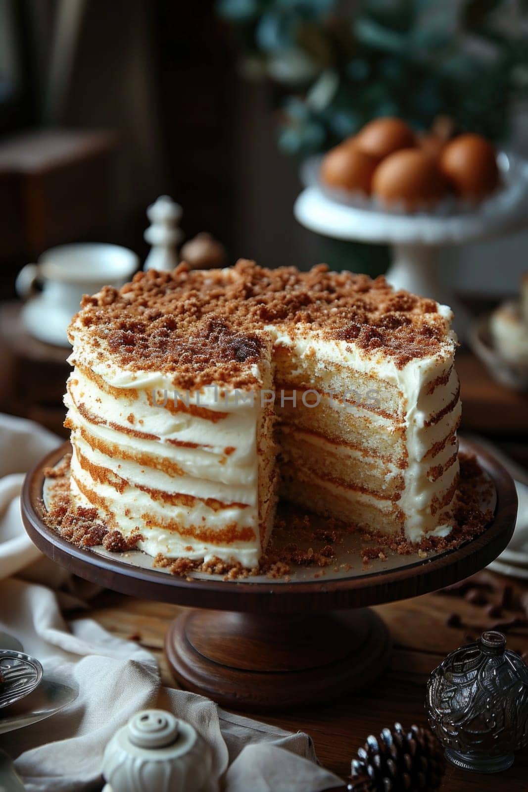 A stylish handmade cake with a cut-out piece stands on the stand of the kitchen table.