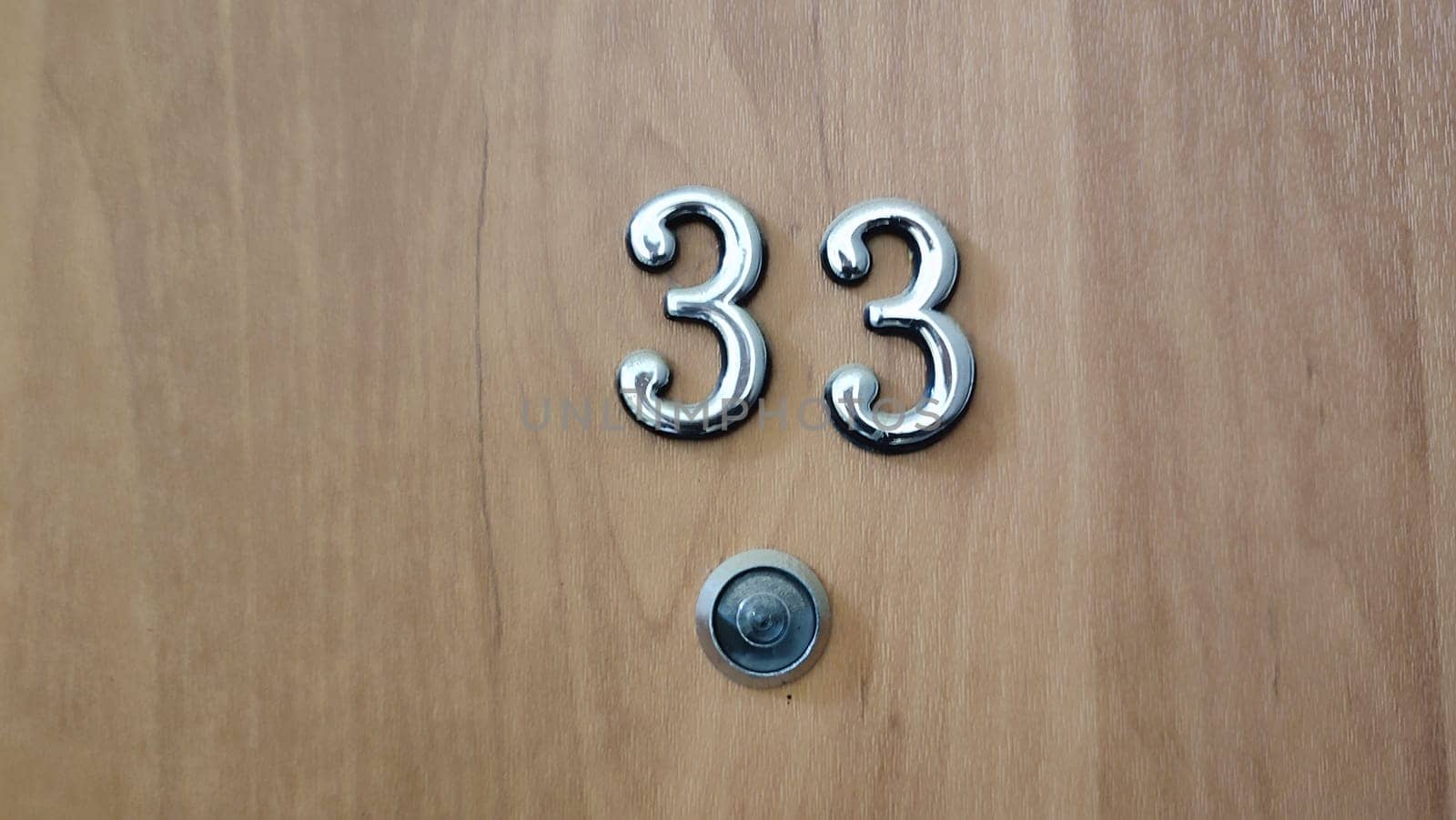 numbers 33 on a white exterior apartment door, symbol objects, sky. High quality photo